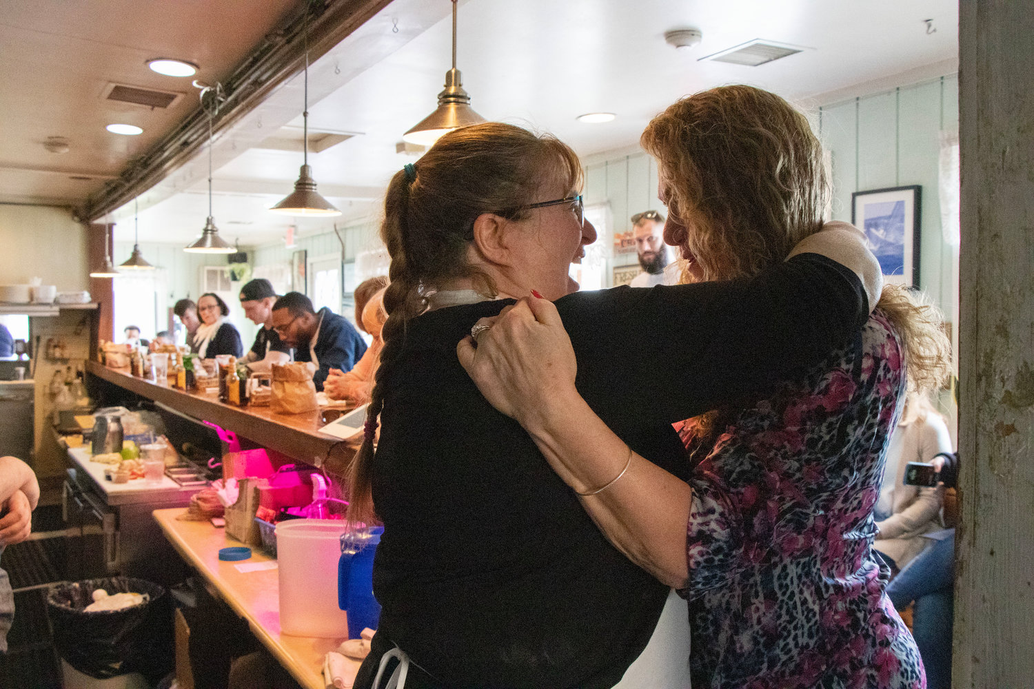 Cindy Morse gives a goodbye hug to longtime customer Ann Greenman on Friday morning.