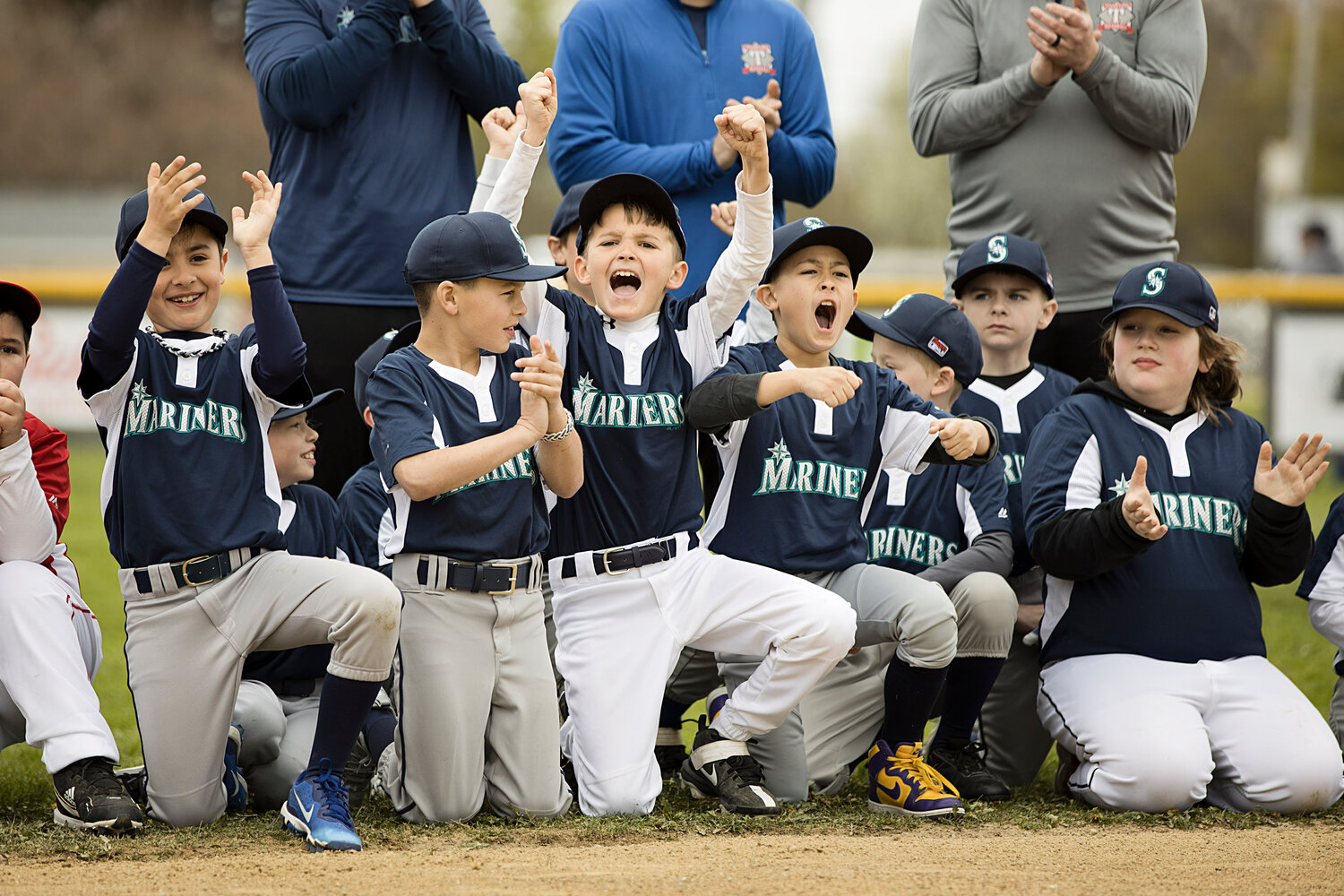 Sam Champman (center) cheers with the Mariners as their team is announced during Opening Day.