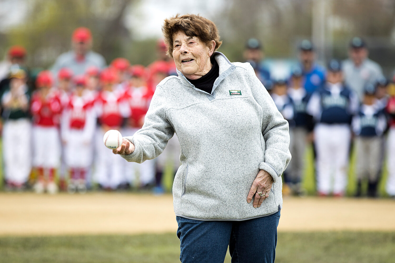 Former Tiverton Little League president Claudia Linhares throws the first pitch during Tiverton baseball's Opening Day ceremony Saturday. 