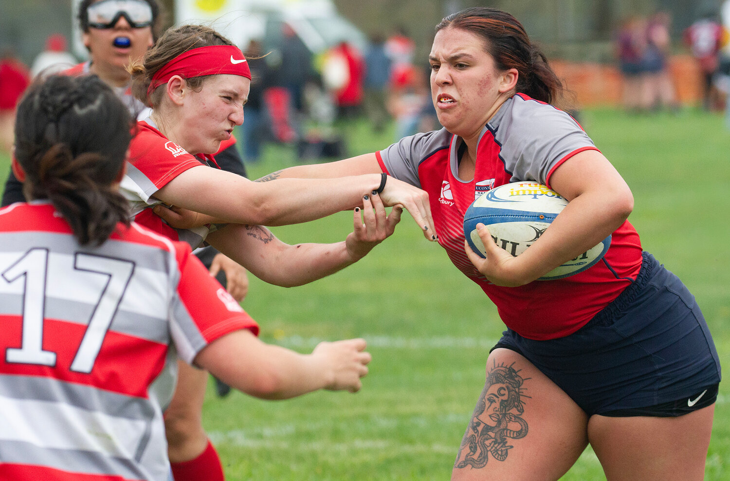Marist College rugby players Melina Serrao (left), Ryann Anderson and Amanda Paulus attempt to pull down University of Connecticut fullback Tempest Rosario.