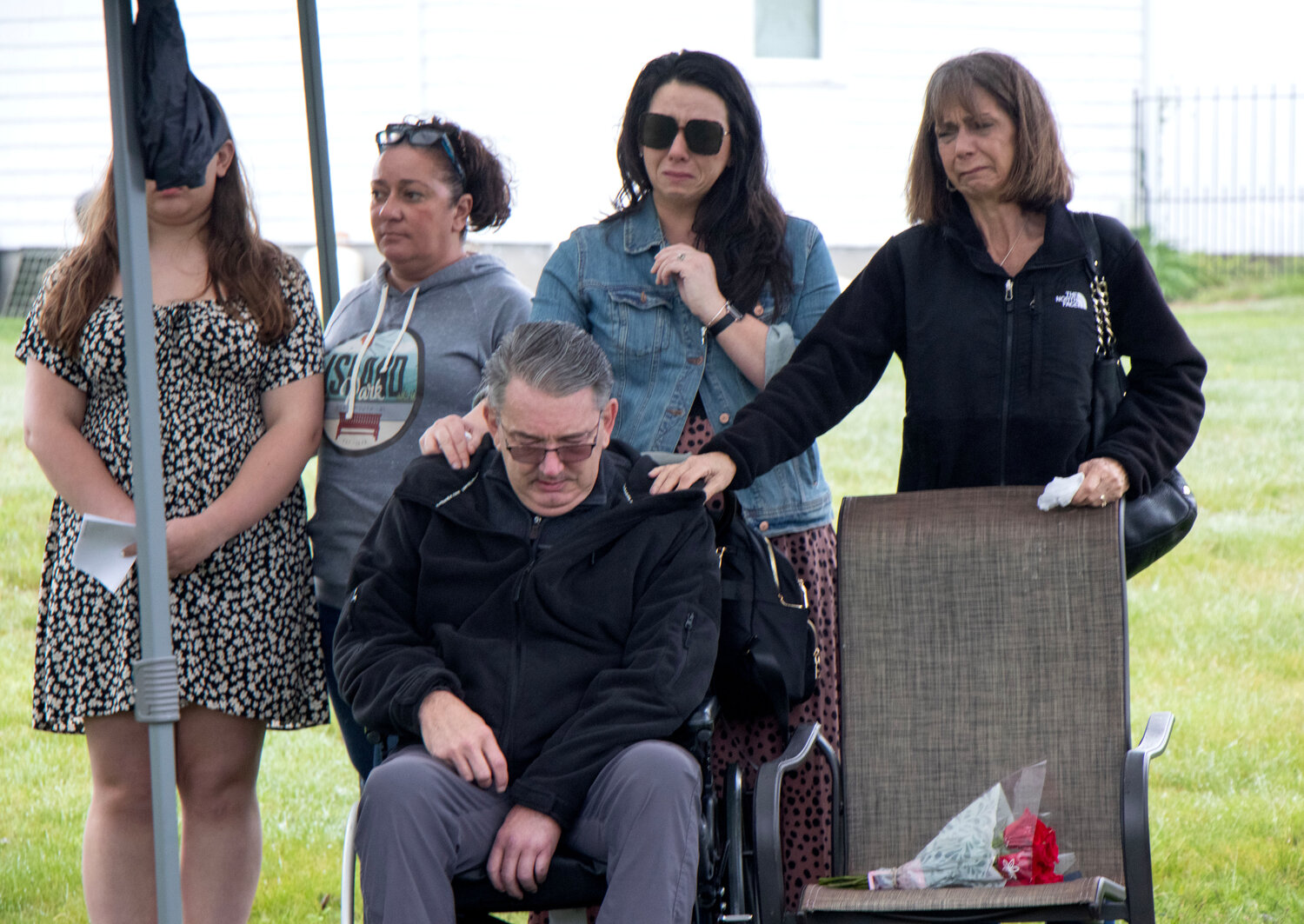 Jeffrey Sias is comforted by his daughter, Amanda Spear-Purchase (standing, second from right) and his wife, Annemarie Sias (right), during the vigil. The Siases lost their son, Samuel Elijah Sias, after he jumped from the Mt. Hope Bridge on Dec. 2, 2022. He was 26. At left are Meredith Kidd (partly obscured) and her mother, Kristen Kidd.
