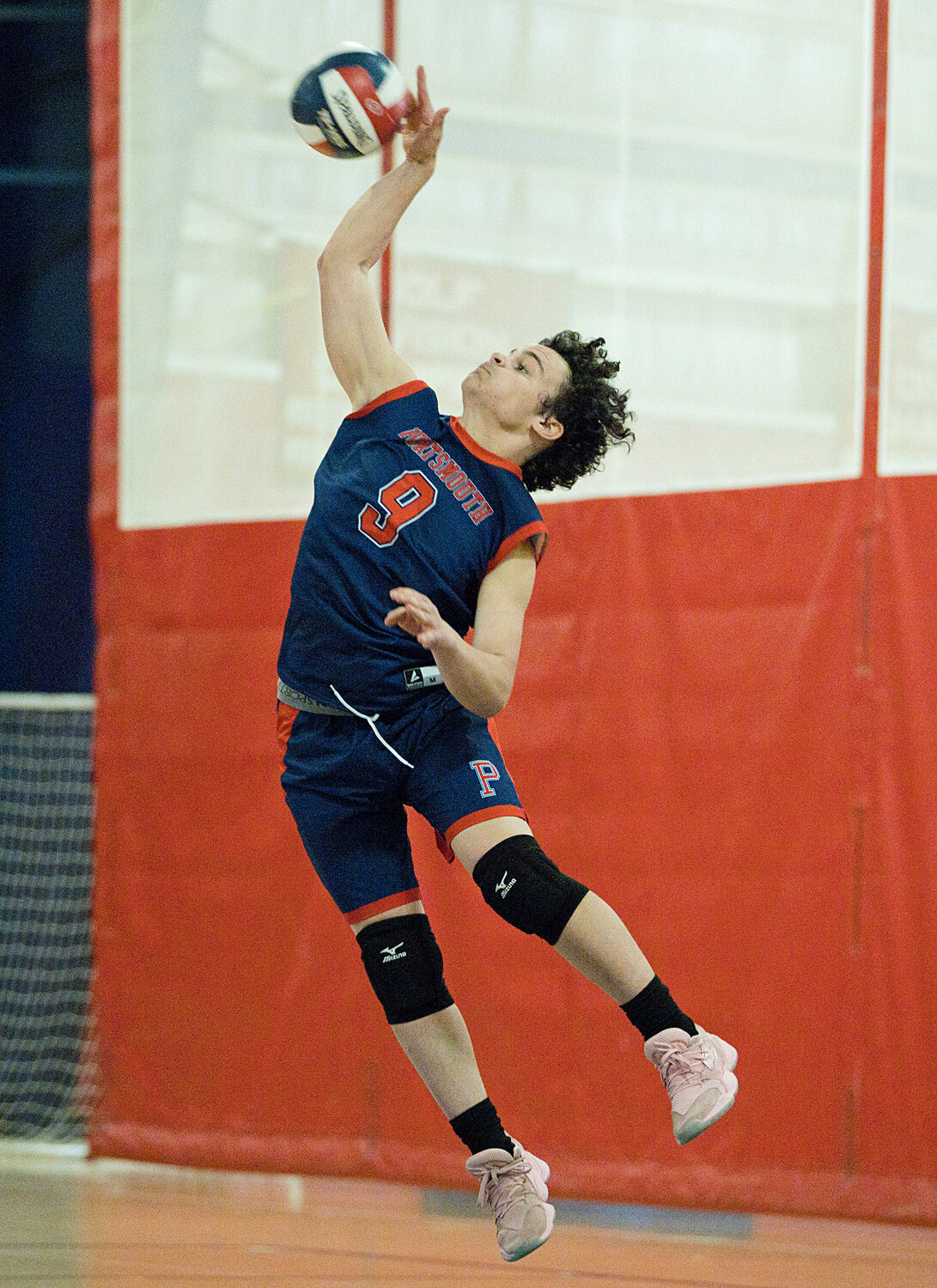 Adam Banks sends a jump serve over the net.