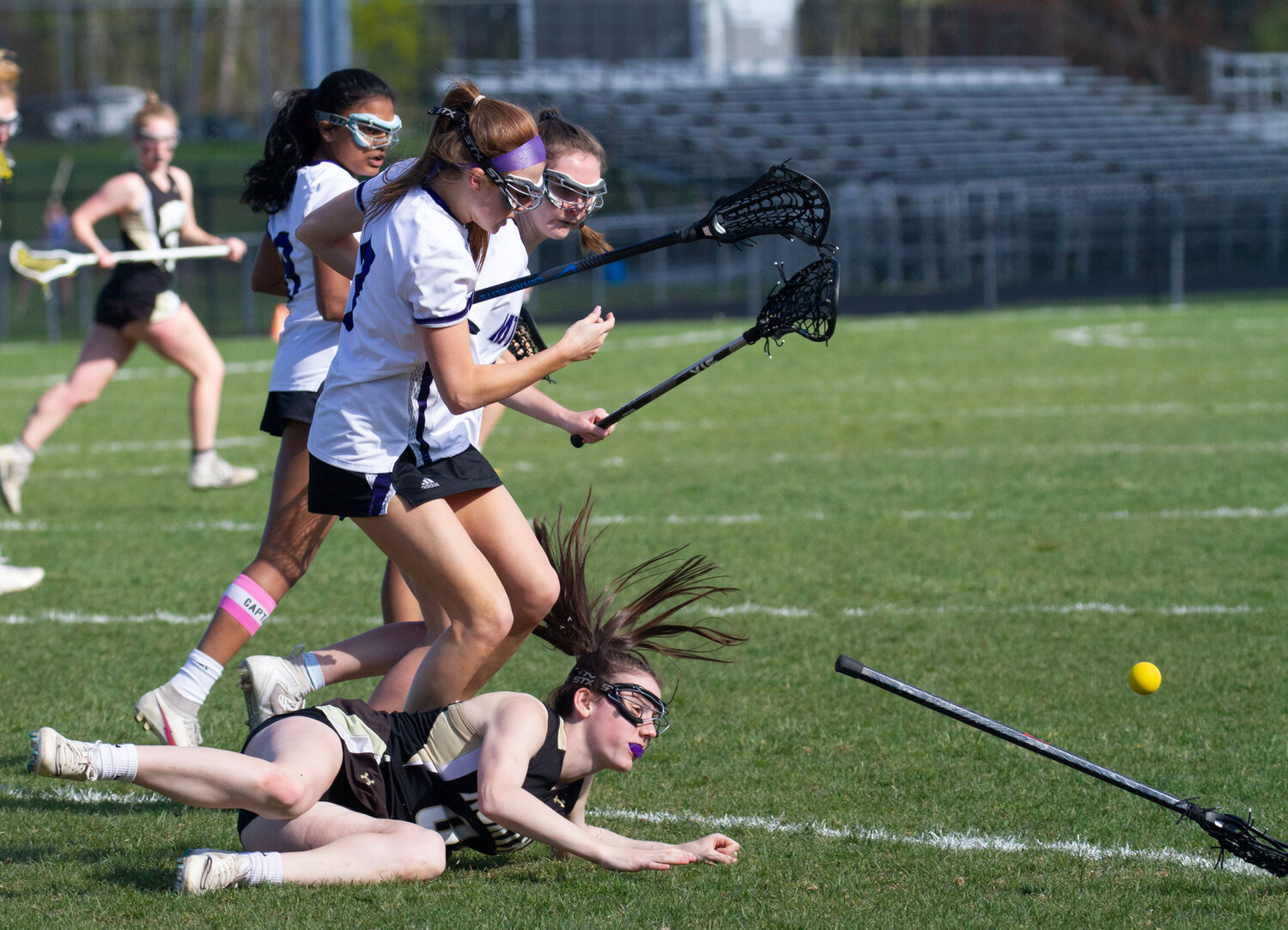 Lola Silva (middle) and teammates knock a North Kingstown attacker to the ground.