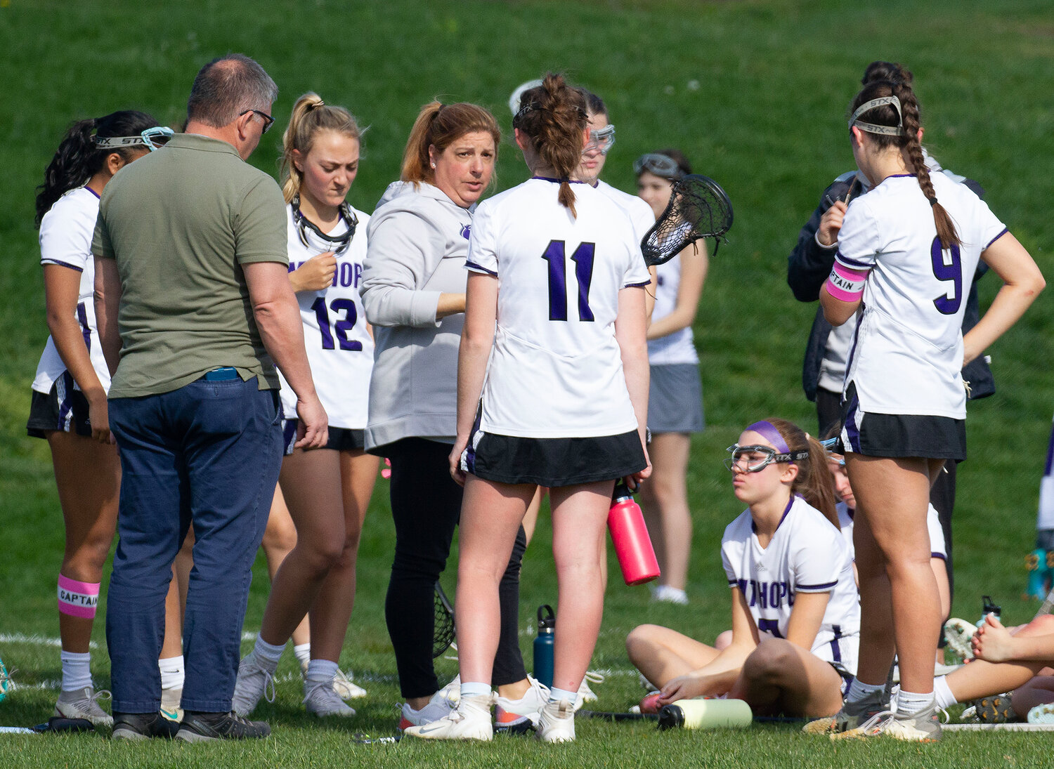 Head coach Kerri Giarrusso (middle) speaks to Ella Quesnelle between quarters during the North Kingstown game.