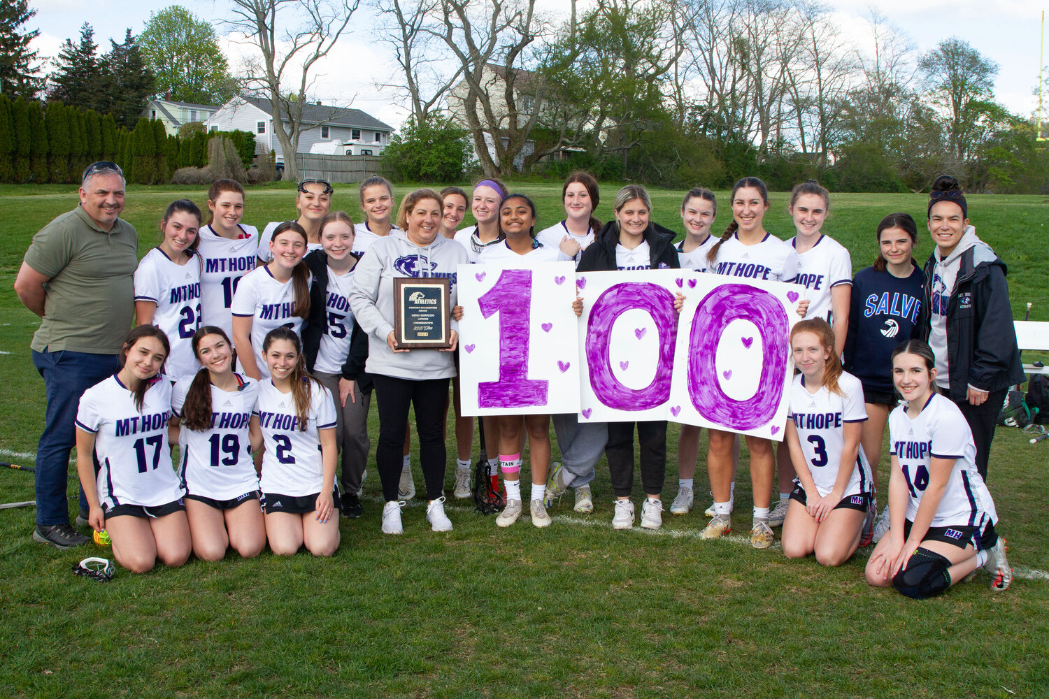 Head coach Kerri Giarrusso (middle) and the girls lacrosse team pose for a photo before the North Kingstown game. Giarrusso won her 100th game when the team beat Toll Gate on Wednesday and was presented a plaque from athletic director Christy Belisle before the North Kingstown game.