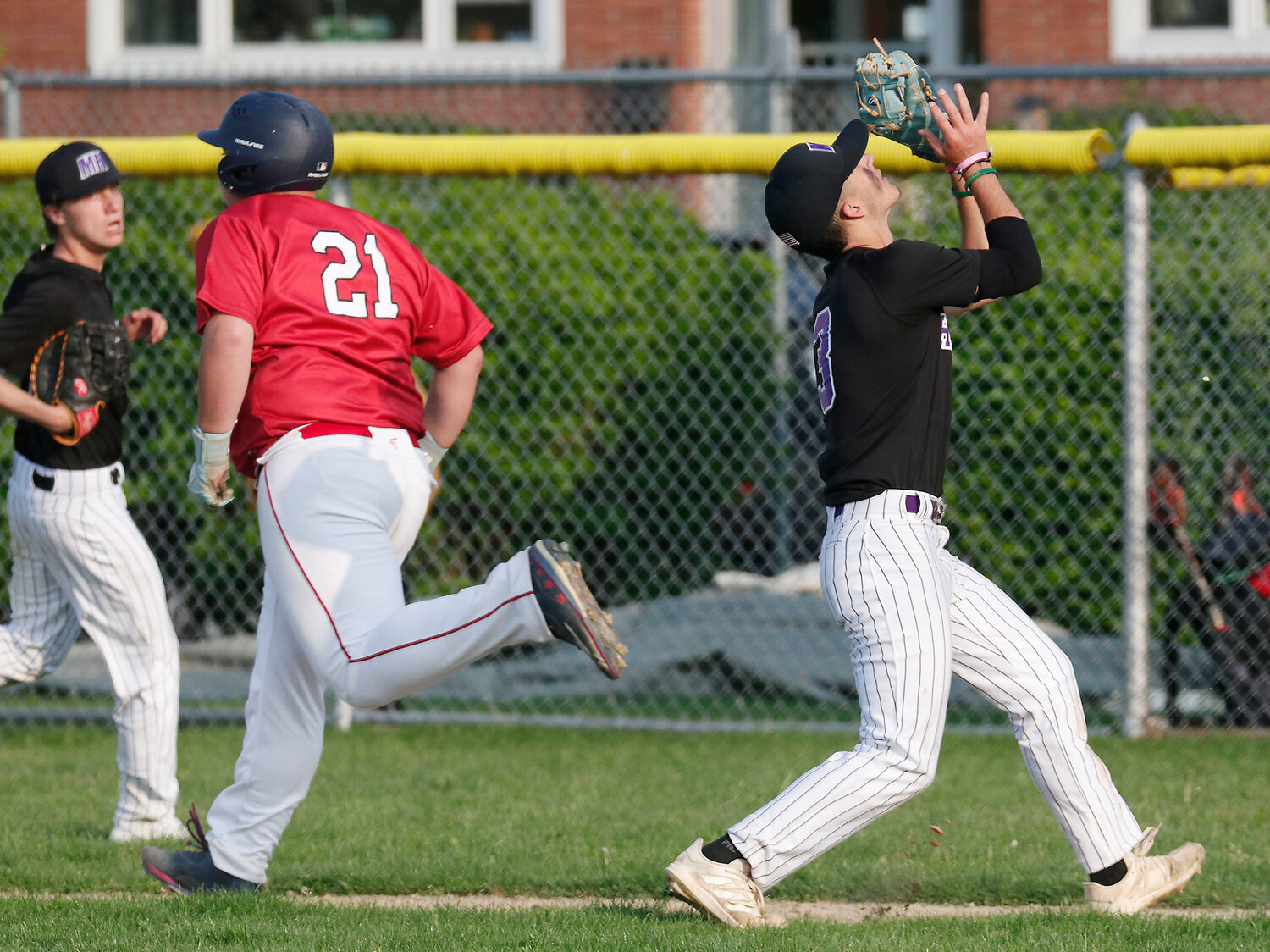 Relief pitcher Parker Camelo (right) runs in to catch an infield fly.