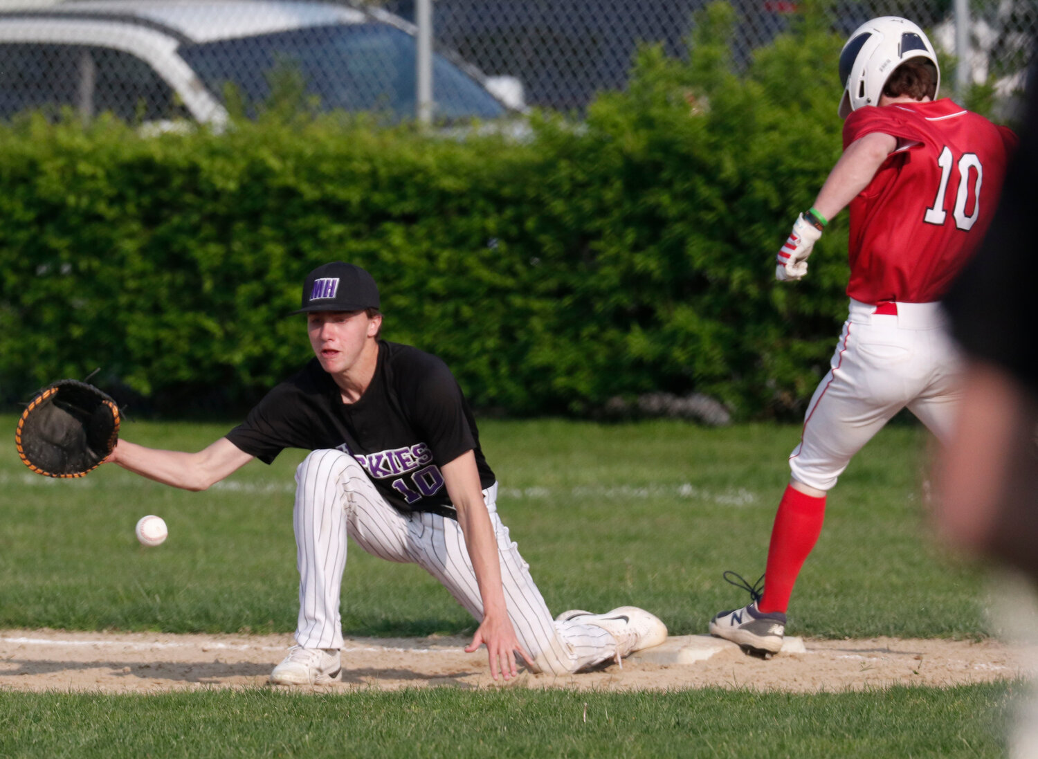 First baseman Lucas Andriozzi attempts to block a throw in the dirt on a play at first base.