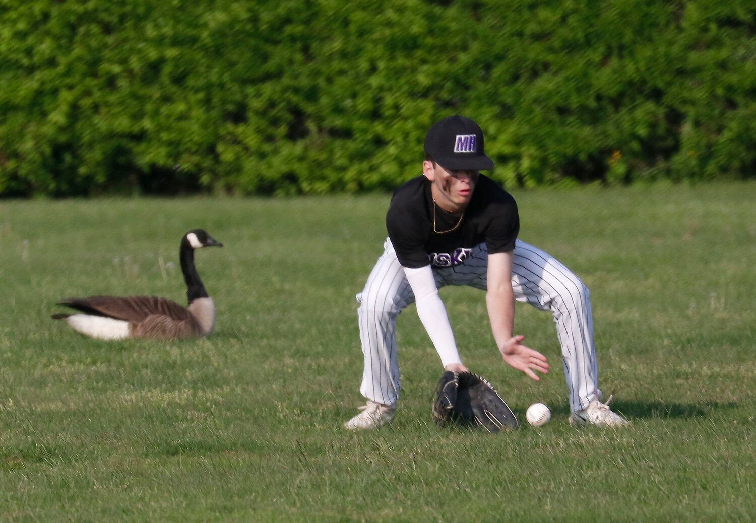 Centerfielder Ethan Santerre fields a Coventry hit with a friend looking on at left.