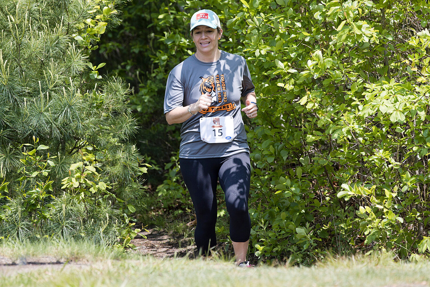 Christine Svendsen emerges from a wooded path while participating in the "Tough Tiger" race, Sunday.