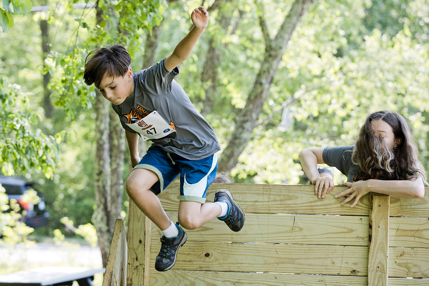 A competitor jumps over a wall obstacle while running the Tough Tiger adventure race.
