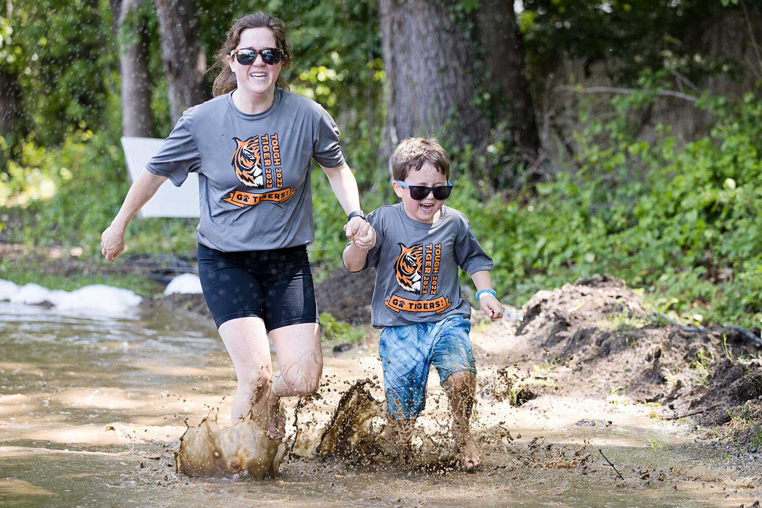 Competitors splash through the mud while participating in Hampden Meadow's "Tough Tiger" event, Sunday.