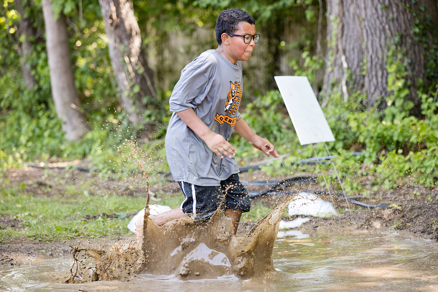A competitor makes a splash while running through a mud obstacle.