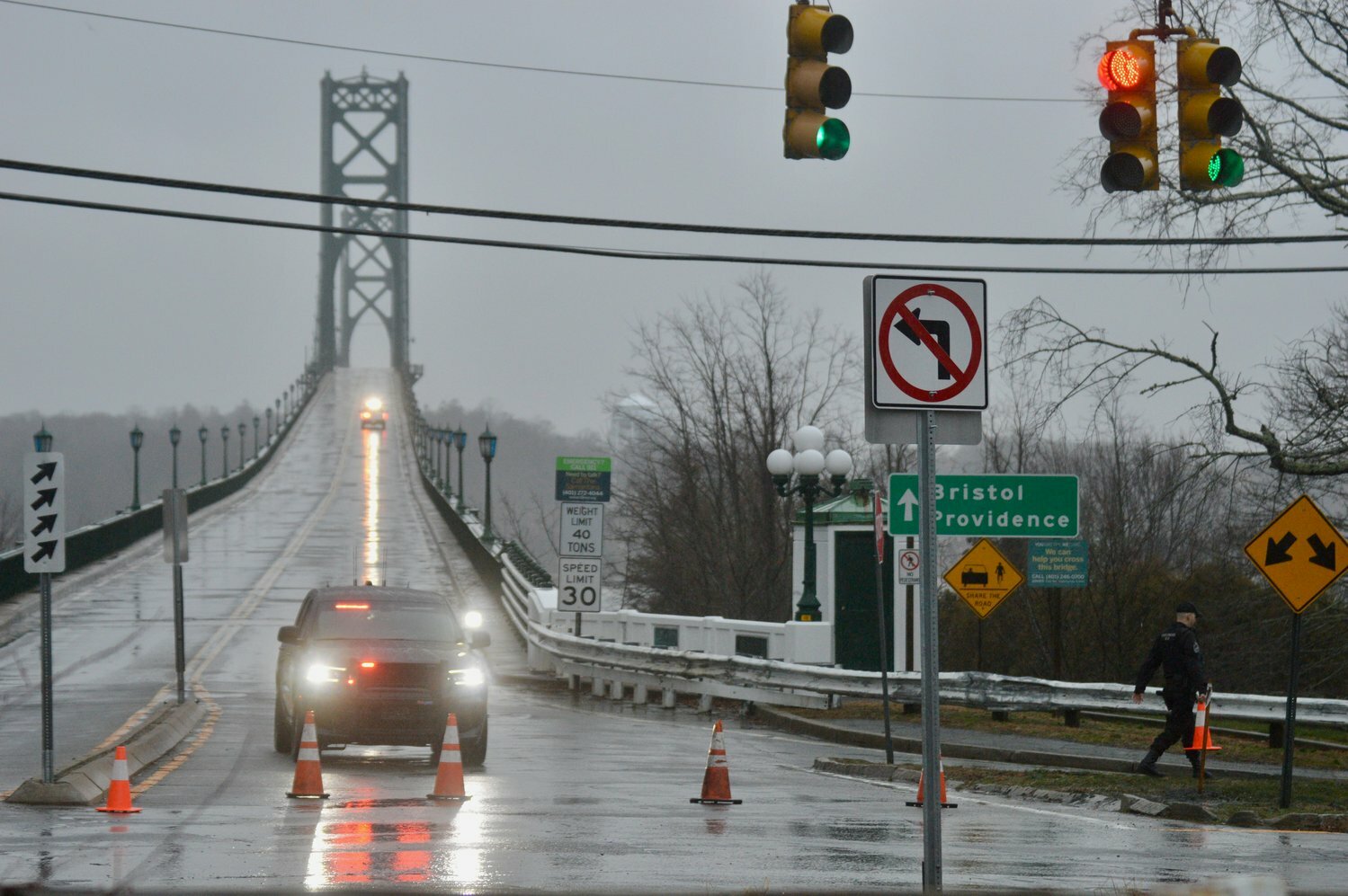 This photo of the Portsmouth side of the Mt. Hope Bridge from January 2022 shows a yellow “Share the Road” sign that includes a graphic of a car and a bicyclist (a “No Pedestrians” sign is to its left). The sign was recently replaced by one stating that bicycles, mopeds and pedestrians are all prohibited from the bridge.