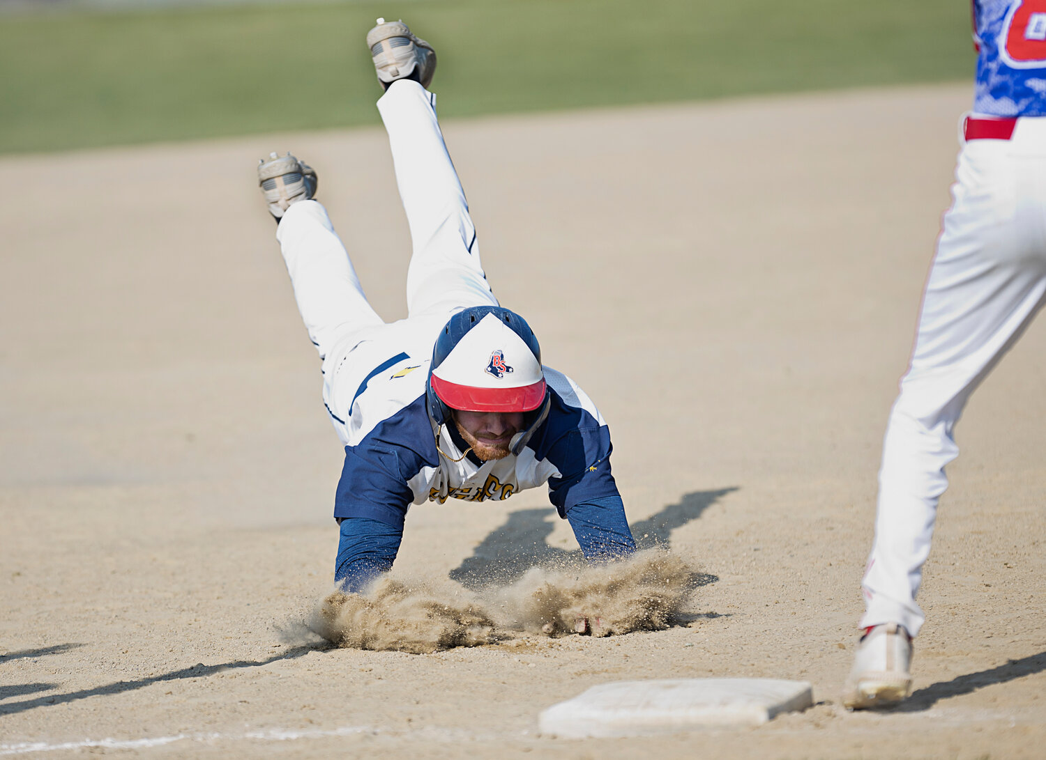 Matt Davis dives safely into third base while competing against Mount St. Charles, Thursday.