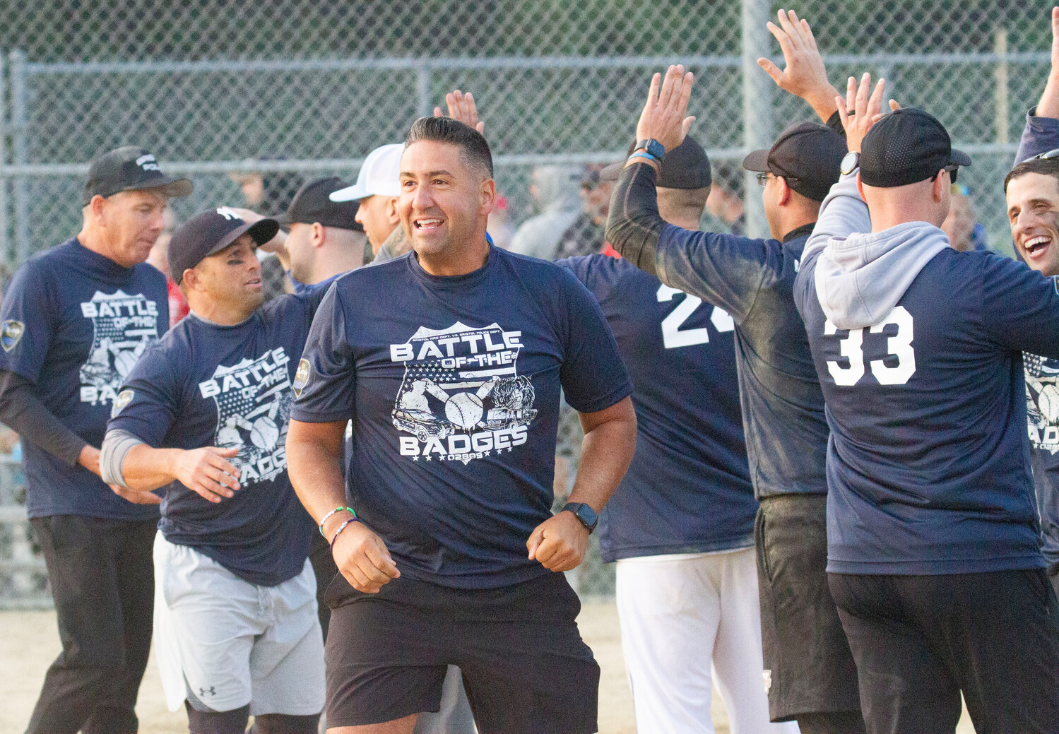 Michael Vieira and the police celebrate at home plater after Major Scott McNally came home for the winning run in the eight inning.