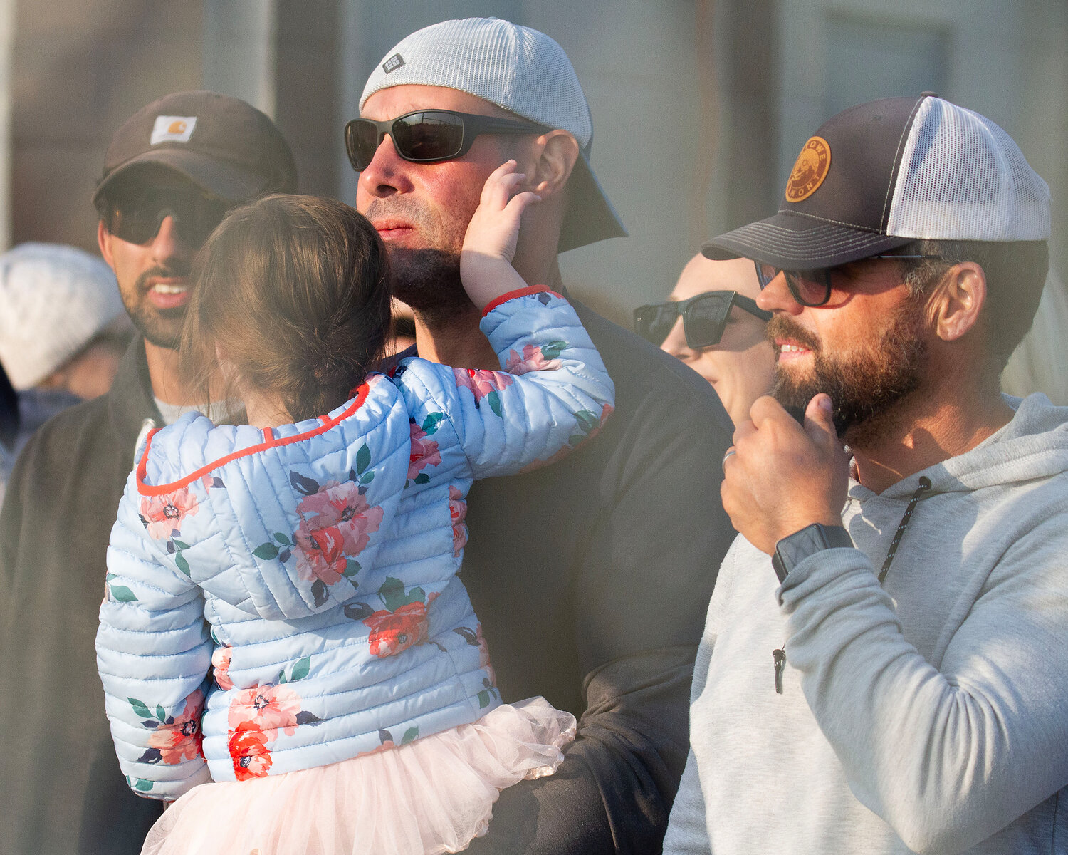 Paul Medeiros holding his daughter, looks on during the game.