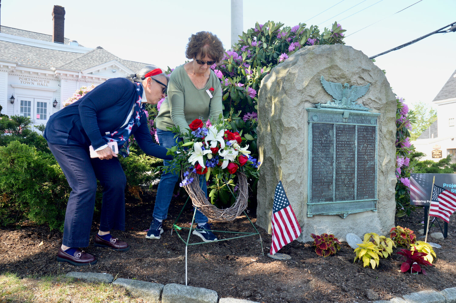 Linda Zagaglia-Gutierrez (left) and Carolyn Evans-Carberry lay a wreath next to the Honor Roll outside Town Hall during Monday morning’s Memorial Day observance.