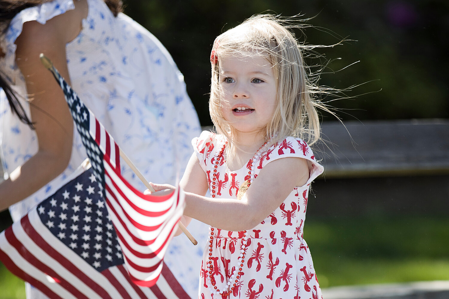 Eleanor Dolan waves a flag while watching Barrington's Memorial Day parade on Upland Way, Monday.