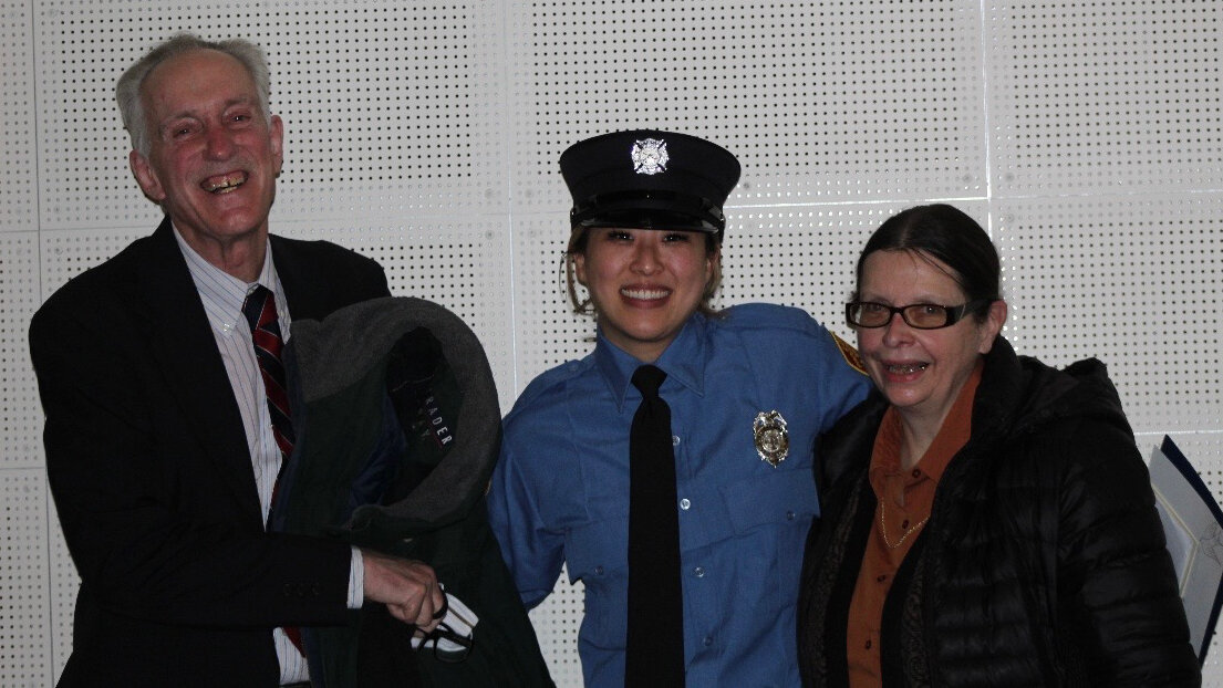 Wendy Clark, at center, with her adoptive parents Roger and Beverly Clark, celebrating her hiring to the East Providence Fire Department in February 2021.