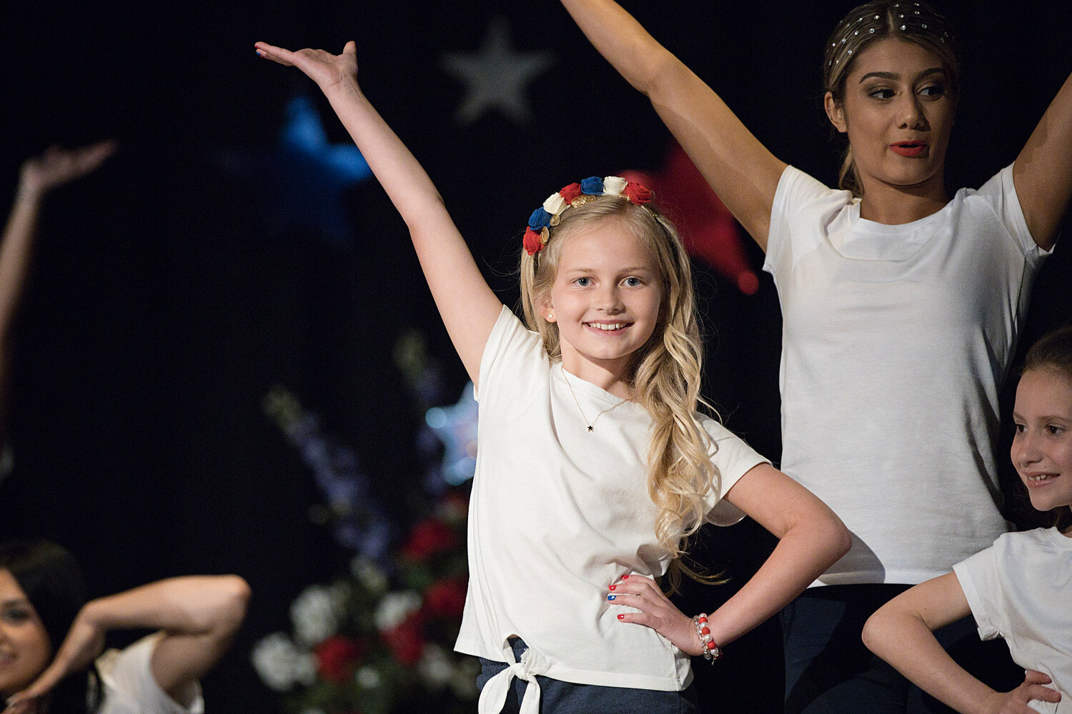 Avery Hicks strikes a pose while dancing with contestants at the start of Bristol's 75th annual Miss Fourth of July Pageant. 