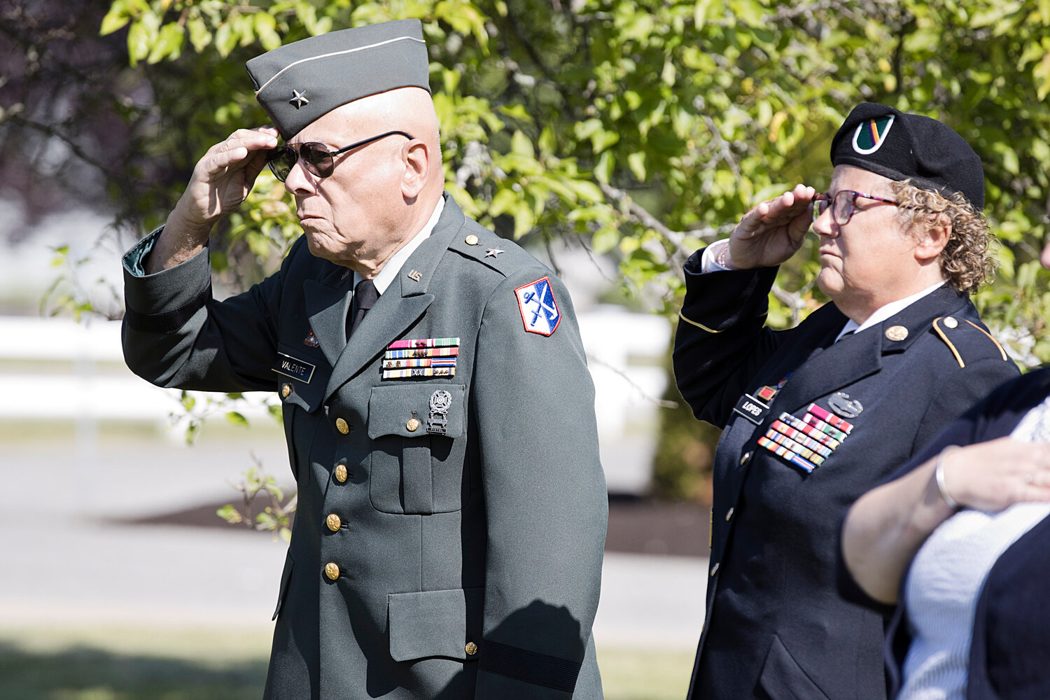 General Valente, Brigadier General (retired) Commander of the 43rd Military Police Brigade, 1990-1995, and Marissa Lopes, Retired Command Sergeant Major - Army, offer a salute during the playing of TAPS.