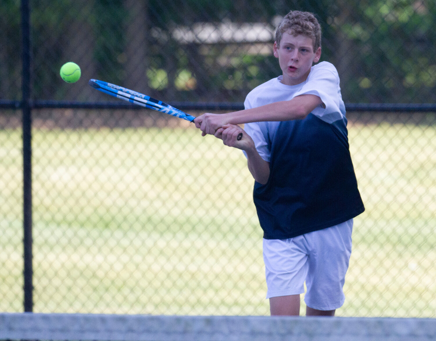 Barrington's Gabe Anderson strikes the ball during a doubles match.