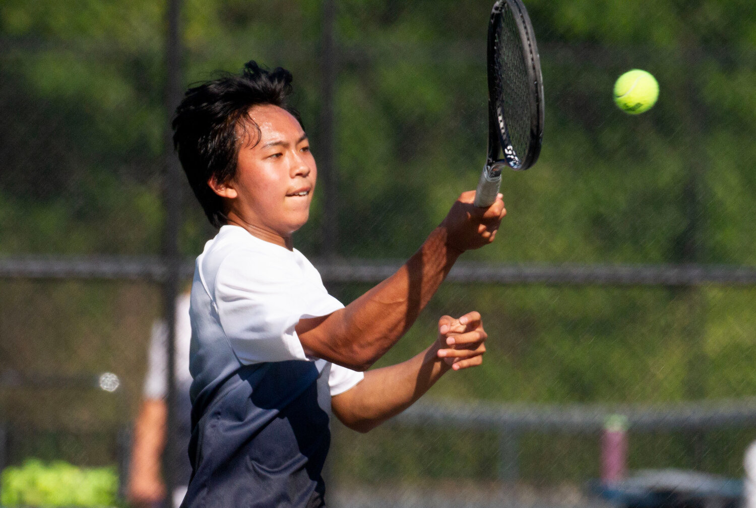 Barrington's Jeremy Kuo battles in his match at third singles against Mount St. Charles.