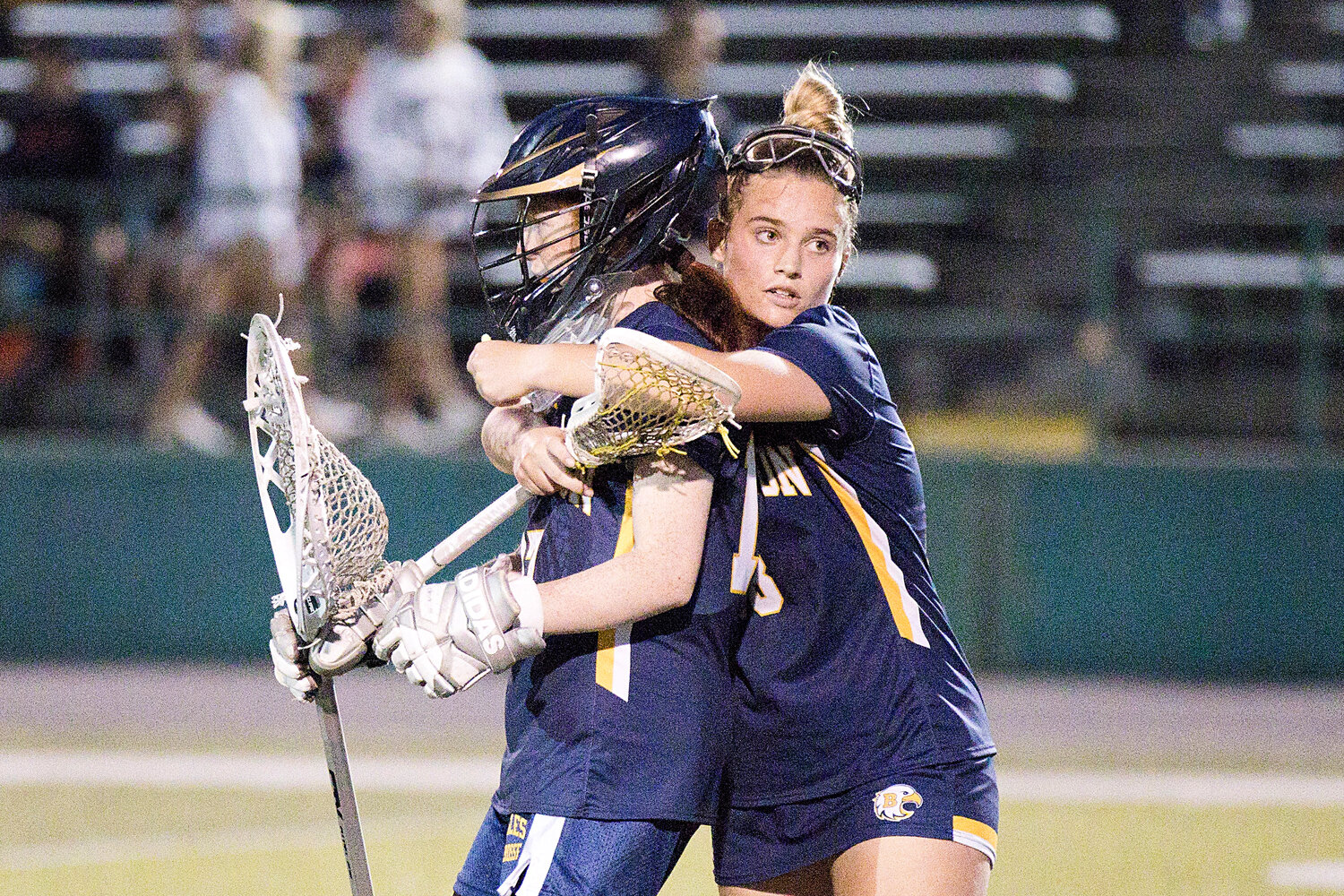 Grace Comfort hugs goalie, Katie McAdams, after the Eagles fall to East Greenwich, 13-11, in the Division I semifinals, Thursday.