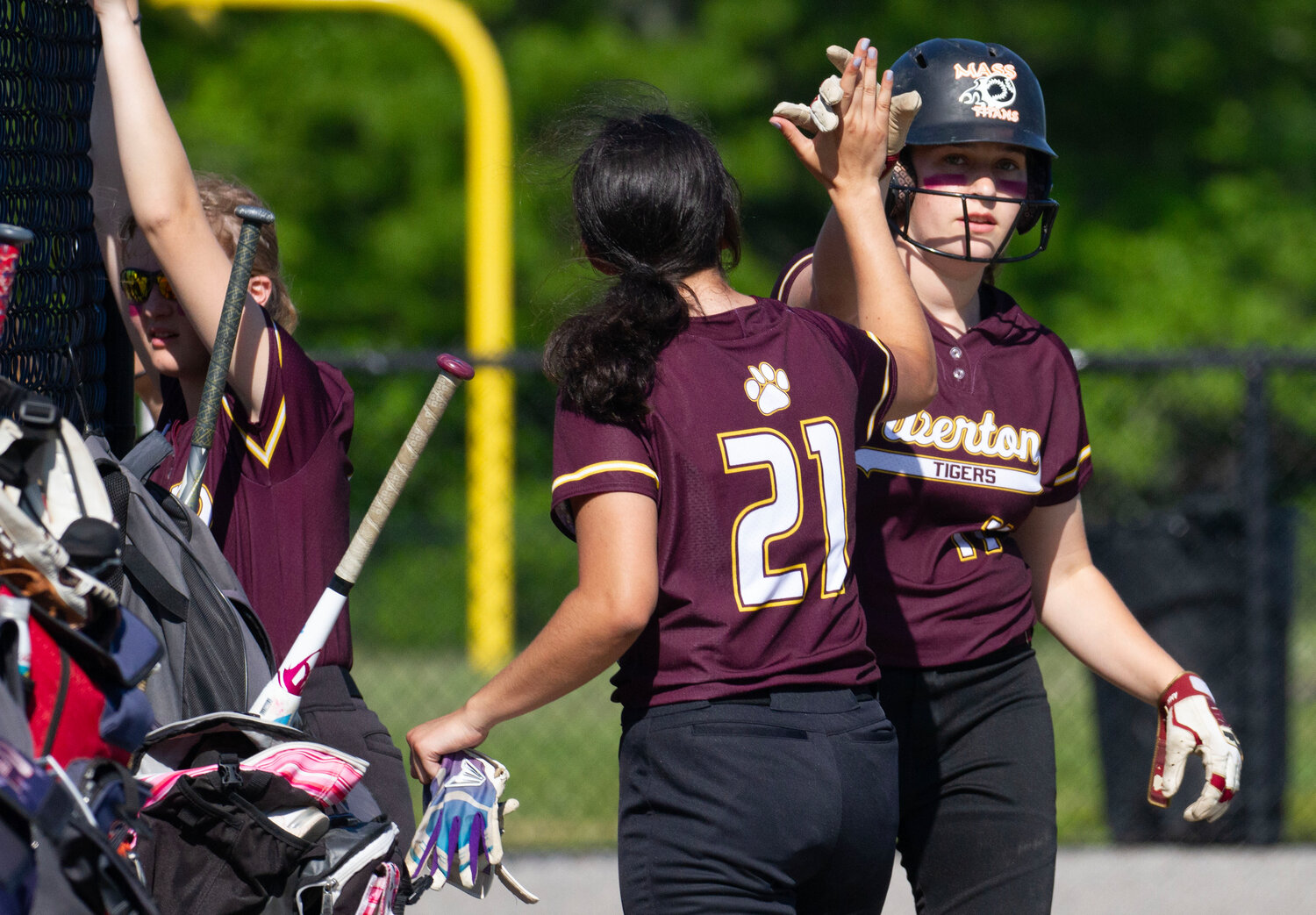 Sam Bettencourt (left) high fives Abby Monkevicz after she came in to score in the first inning. The first baseman belted 4 hits with a triple, drove in a run and scored 5 runs.
