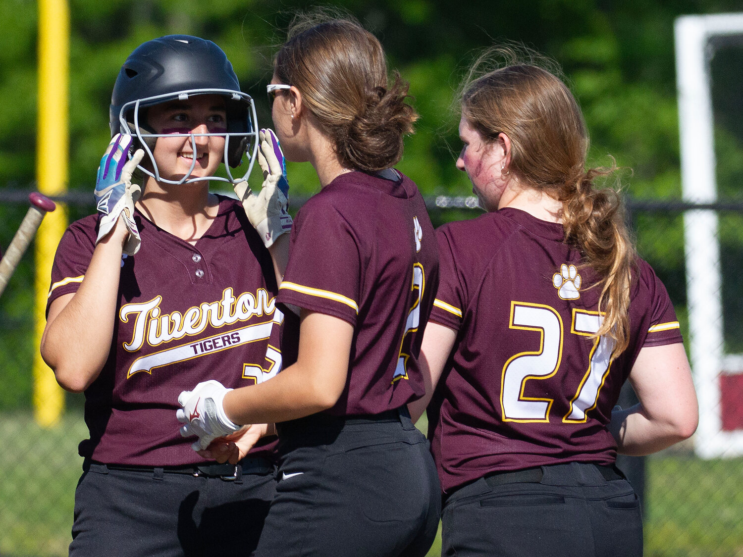 Abbie DeMello (left) receives kudos from teammates after coming around to score in the first inning.