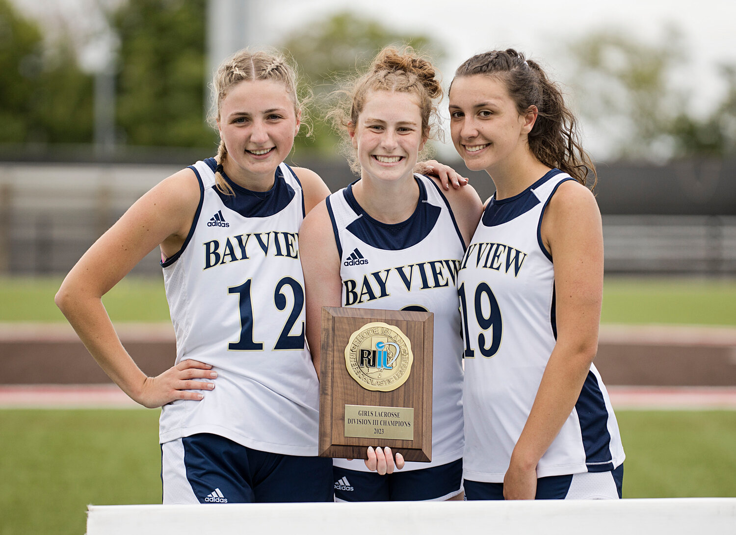 Bay View seniors Olivia Mattos, Elizabeth Healey and Dolan collect the title trophy after the Bengals defeated the Townies in quadruple overtime.