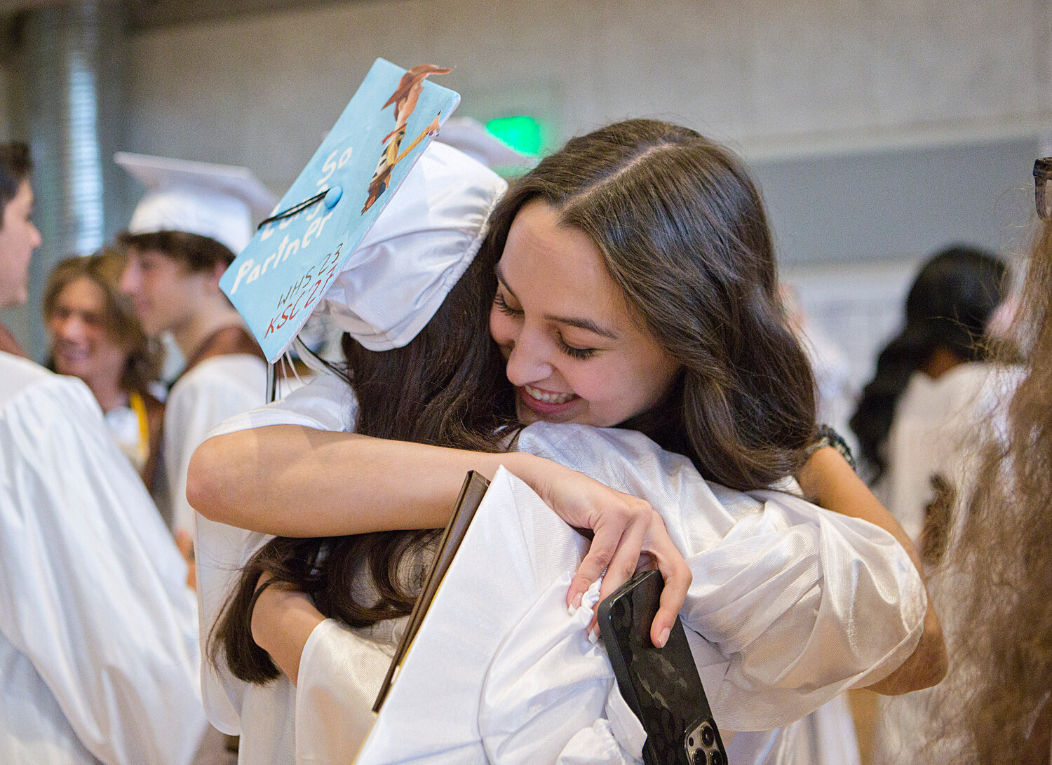 Leah Sylvain (right) shares a hug with a fellow graduate. 