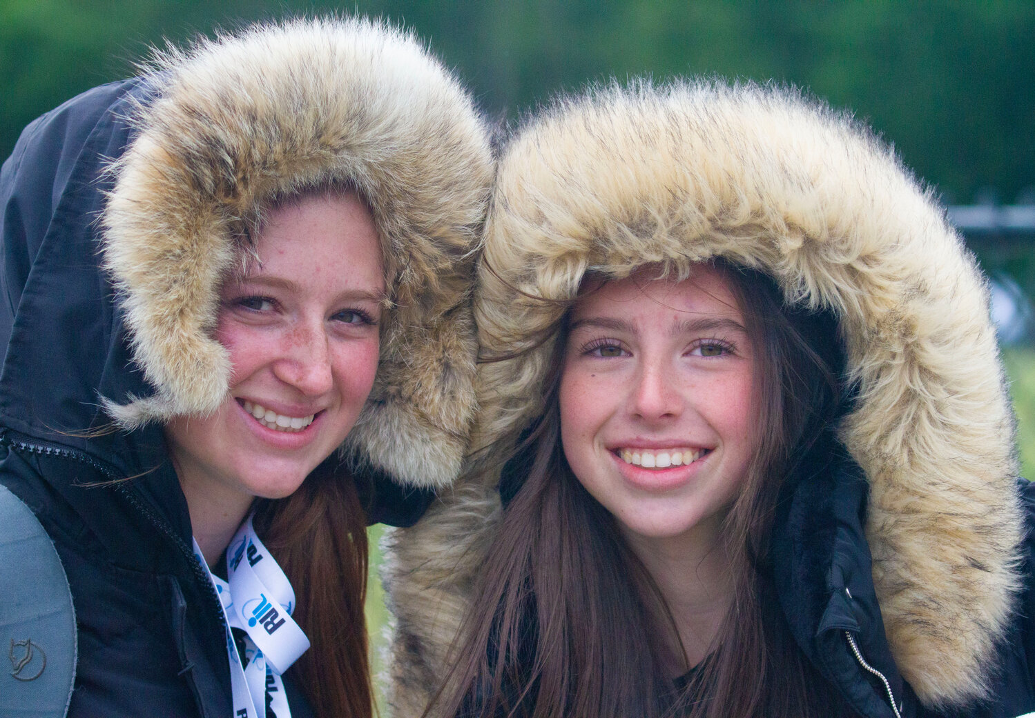 Lola Silva (left) and Kali Rocha of the Mt. Hope track team stay warm in their parkas while waiting to compete.