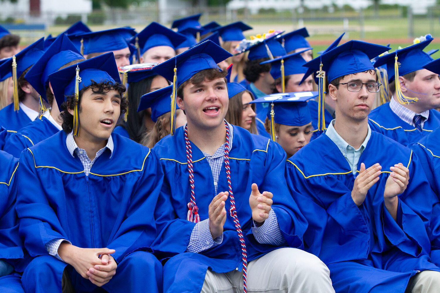Gavin Lesk, Daniel Lemos and Christopher LeClair (from left to right) applaud a speaker during Sunday’s graduation ceremony at Barrington High School.