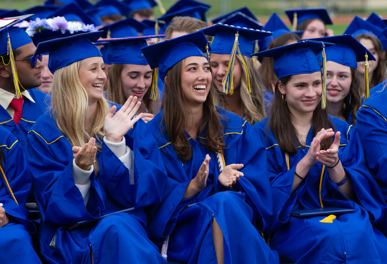 Perry Davis, Sonya Pareek and Anna Saal (from left to right) applaud during the graduation ceremony.