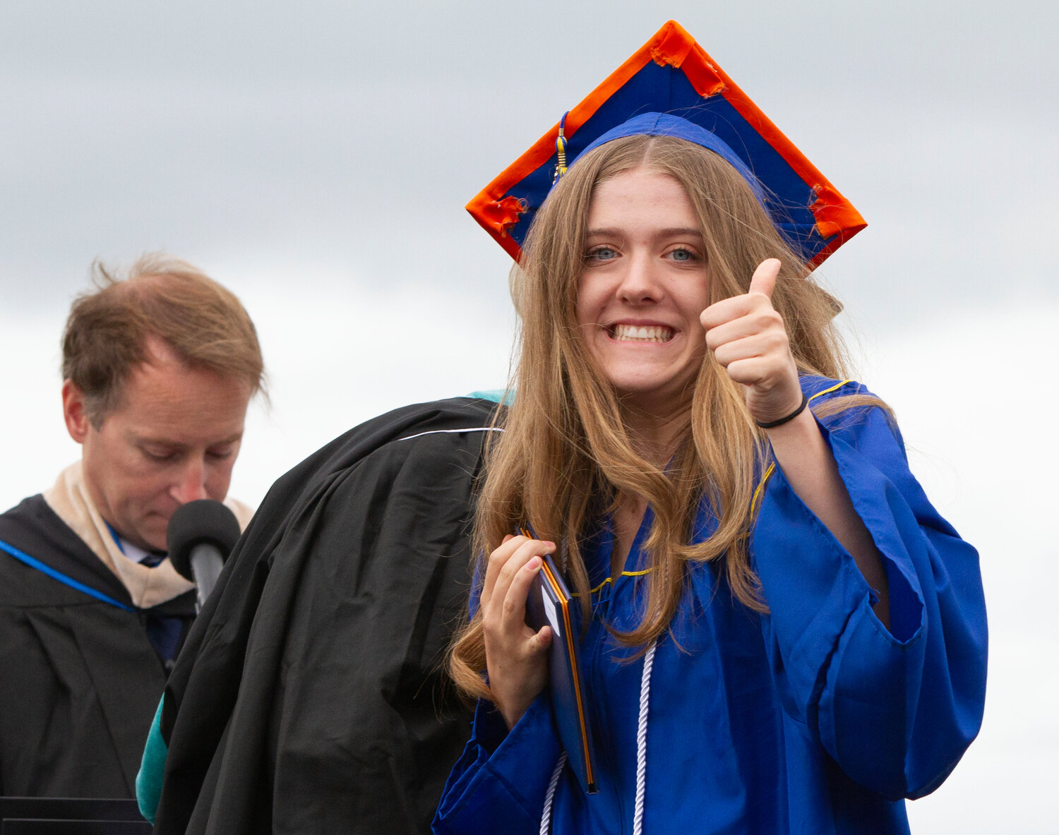 Maddie Kaufman gives a thumbs up after receiving her diploma at the Barrington High School graduation ceremony on Sunday. BHS Principal Chris Ashley is in the background.