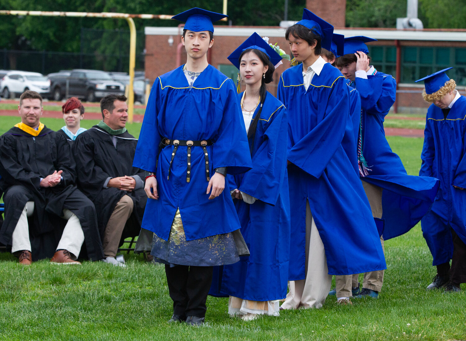 Boheng Huang, Jialin Huang and Matthew Huang (from left to right) wait to receive their diplomas at Sunday’s graduation ceremony.