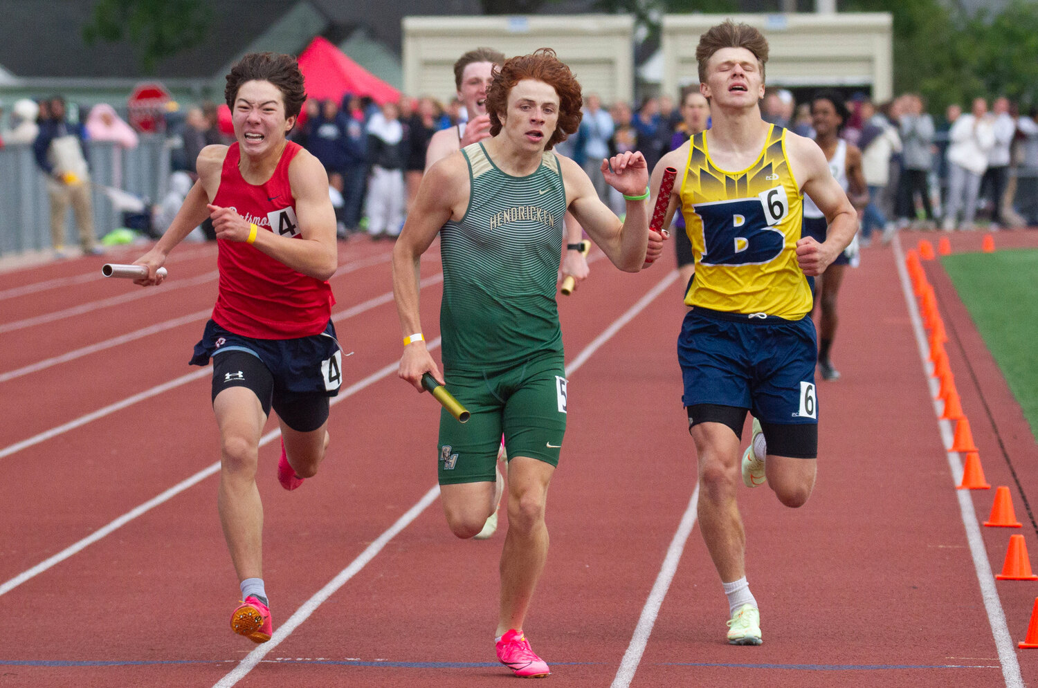 The Patriots Aidan Chen (left) is nipped at the finish line by a Bishop Hendricken runner during the 4x400-meter relay race. The team came in second with a time of 3:31.16. Chen also came in second in the high jump.