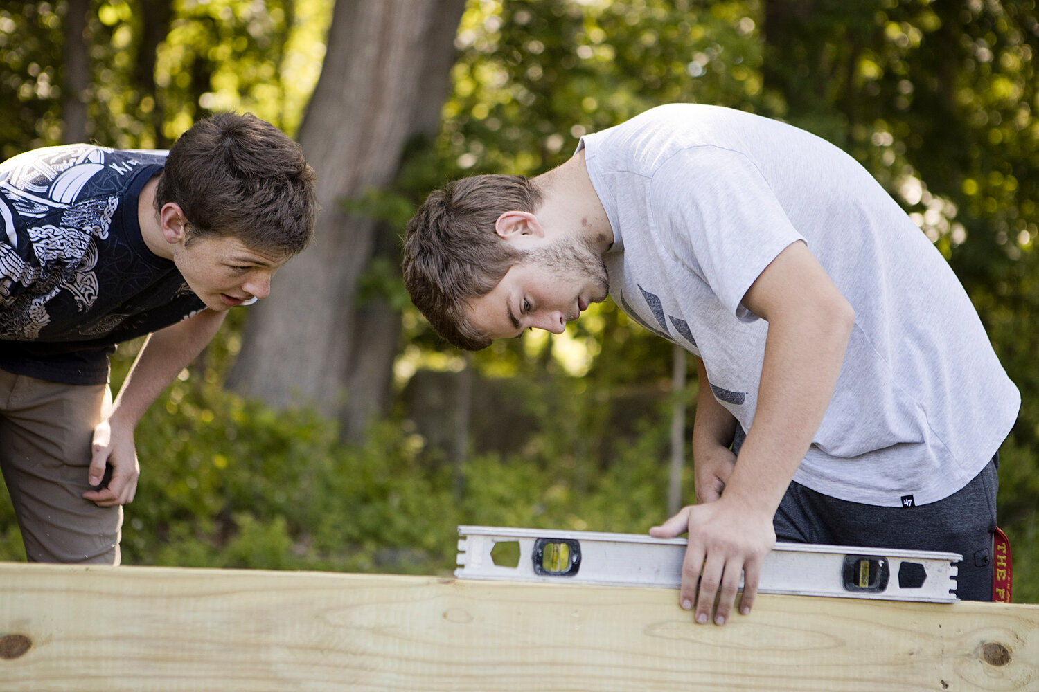 Michael Thibault (left) and Tyler Gow make sure the walls are level after installing a "Gaga Pit" at Hugh Cole Elementary School, Wednesday.
