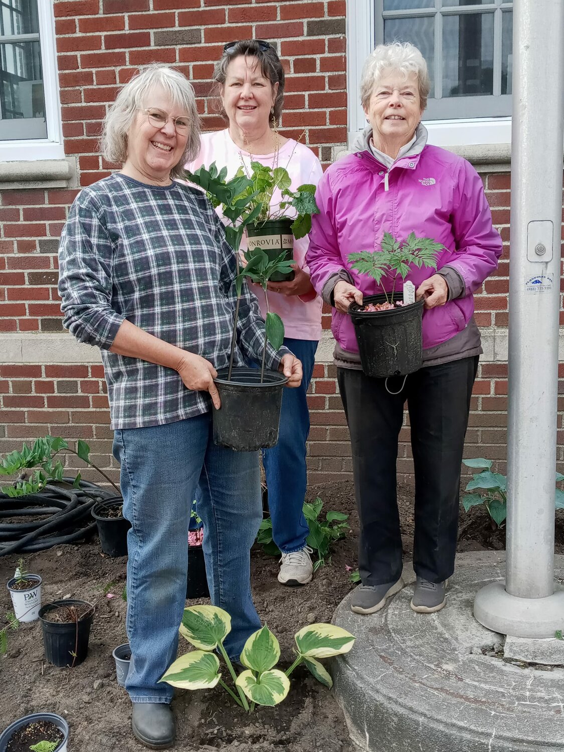 Dottie Dylag, Carol Serbst and Wendy Brennan prepare to plant native species in the large lot to the side of the Warren Post Office on Child Street on Sunday.