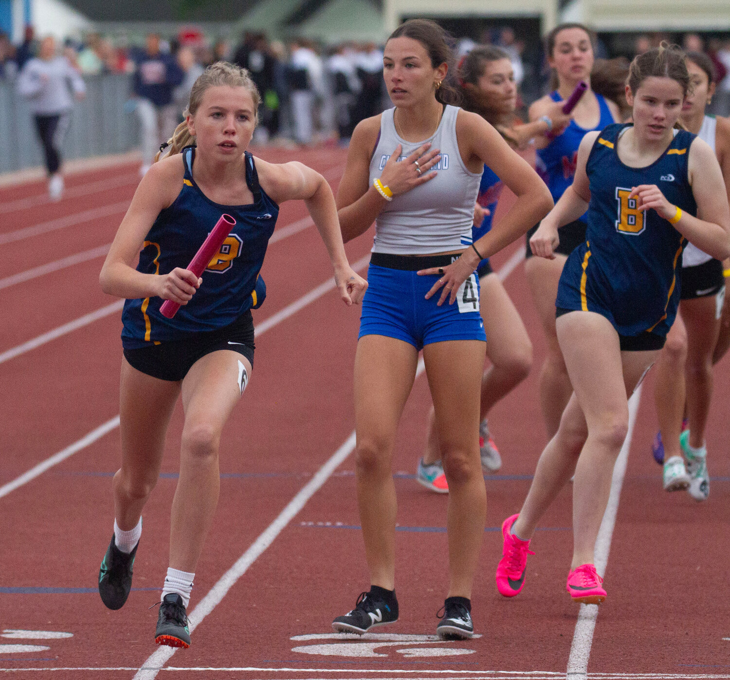Barrington's Faith VanNess (left) runs a leg of the 4x400-meter relay race at the state track championship.