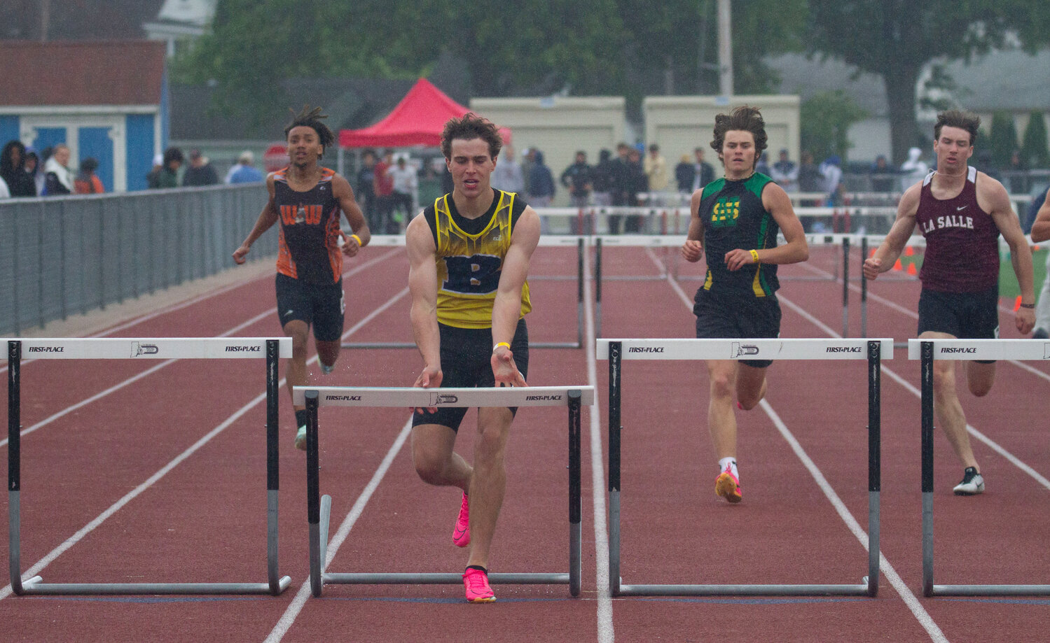 Barrington's Ethan Knight pushes over a hurdle in the 300-meter hurdles race.