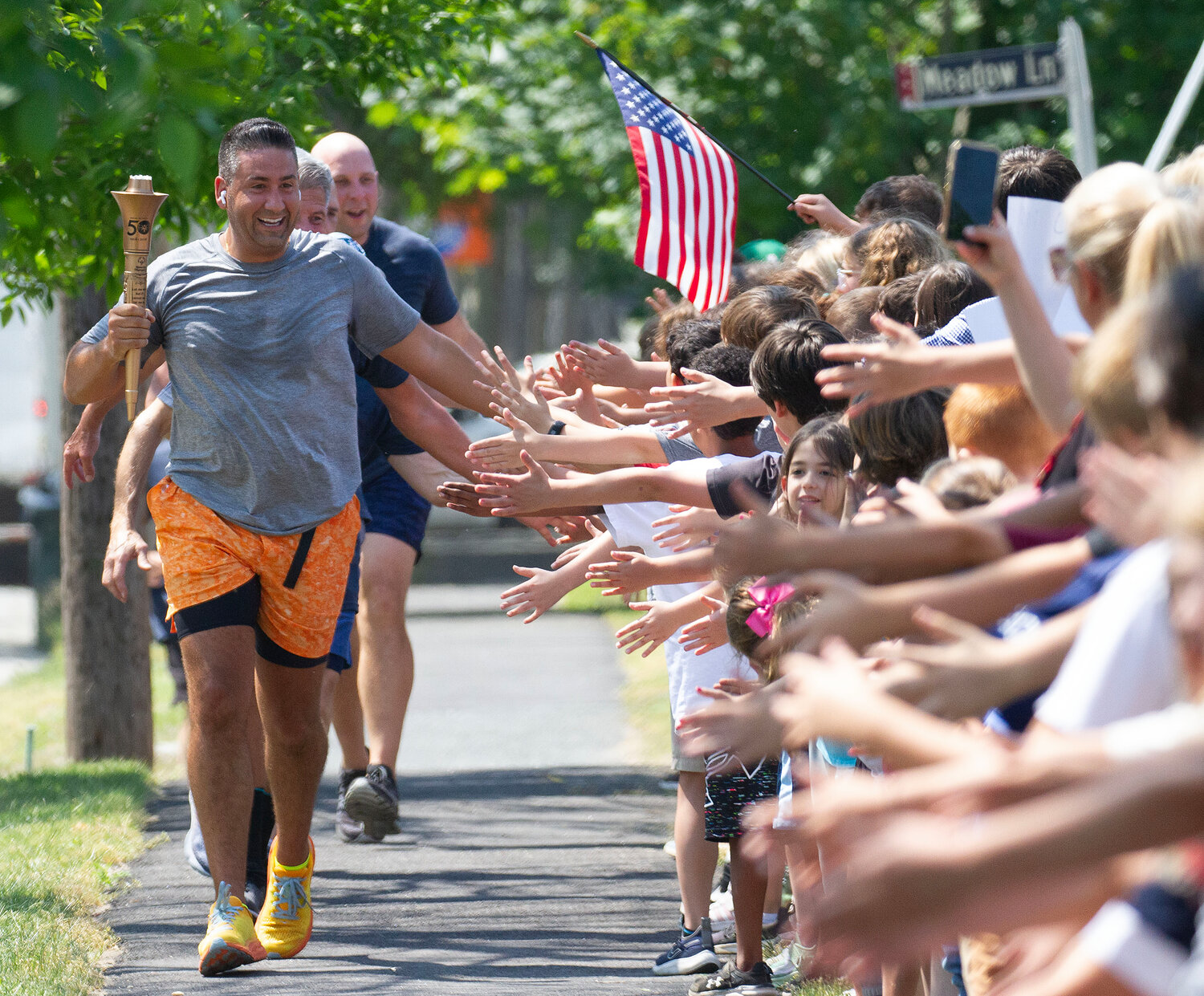 Bristol police officer Mike Vieira high fives Rockwell students while running the torch run with Police Chief Kevin Lynch and other officers on their way to Warren and Barrington.