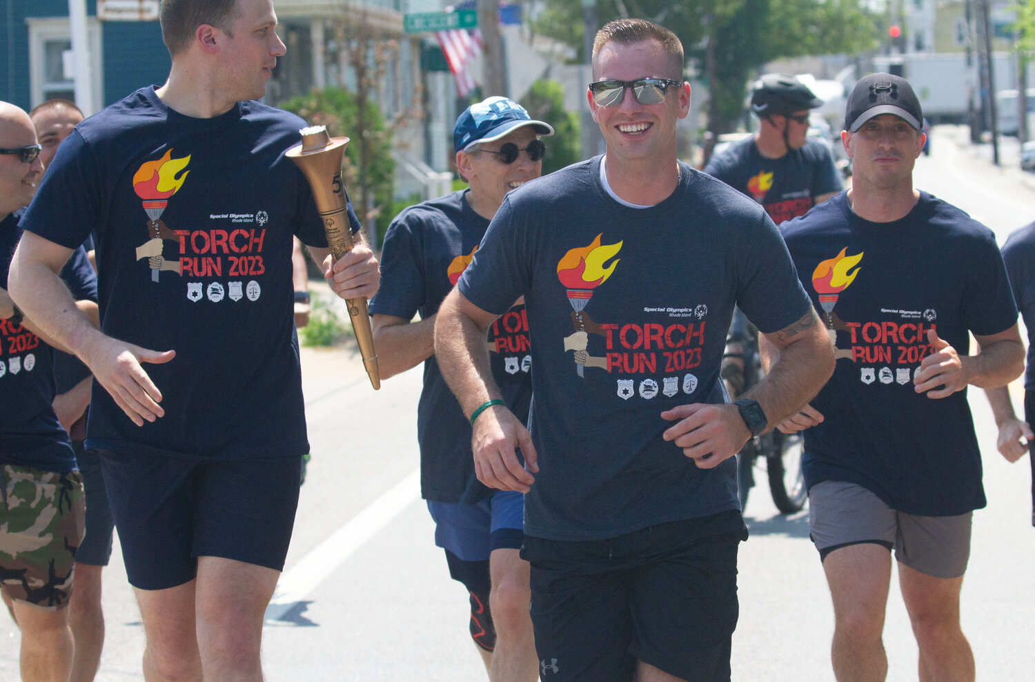 Barrington Police Officer Sean Murphy (left) carries the torch while running with other law enforcement members.