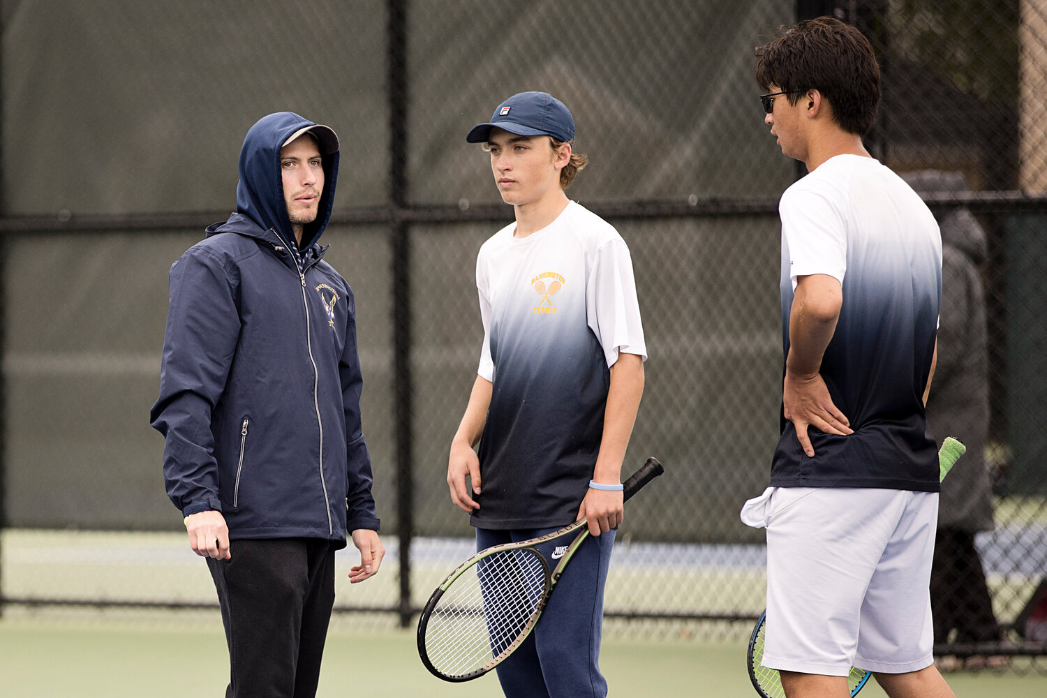 Head Coach Story Salit (left) gives advice to doubles players, Henry Birbiglia (middle) and Dawen Cheng.