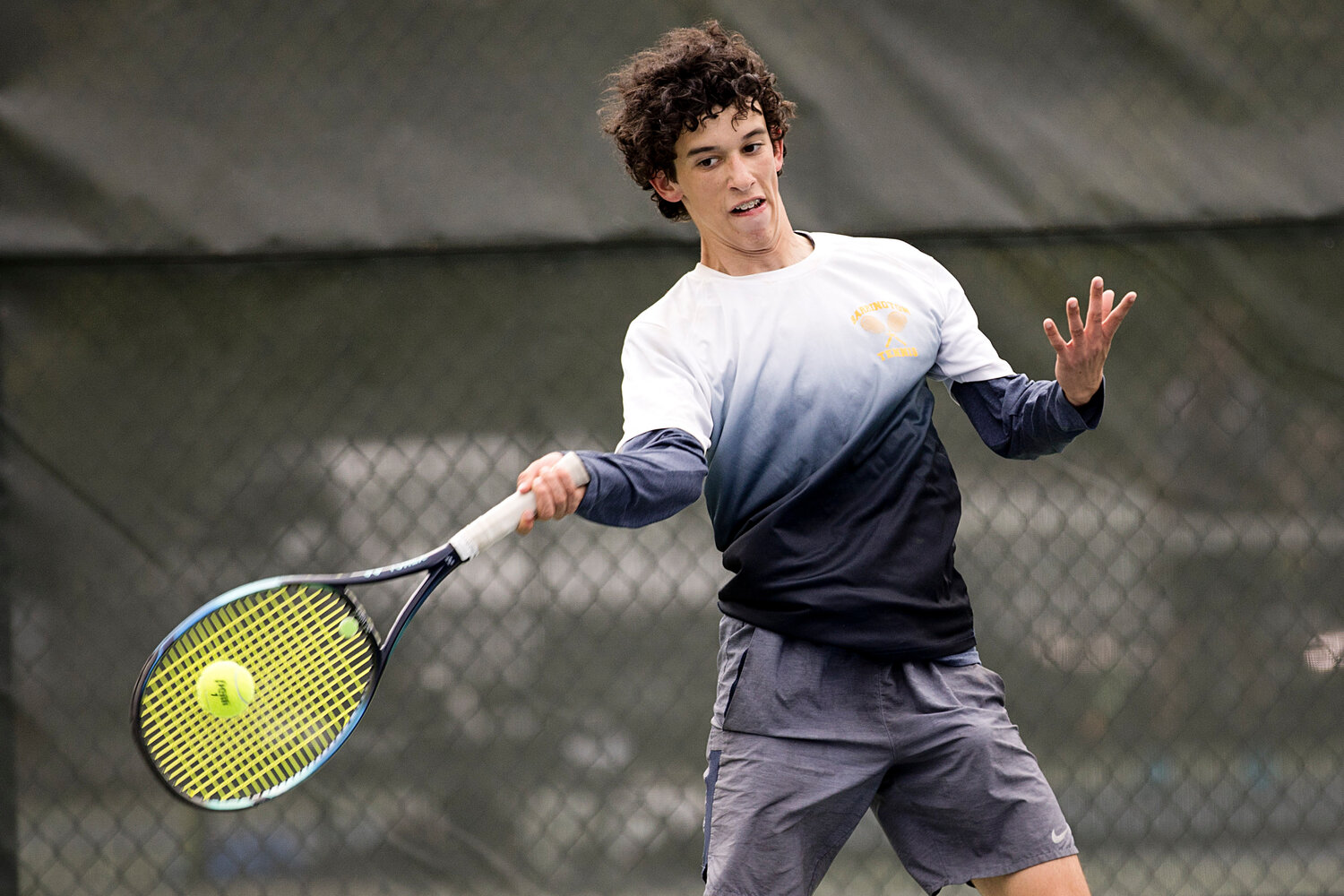 No. 1 singles player Luke Sapolsky hits the ball back over the net while rallying with his LaSalle opponent.