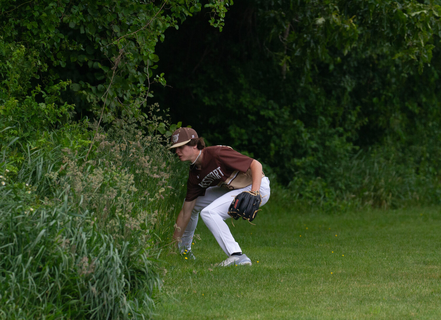 Dylan Kirby digs the ball out of the woods in left field.