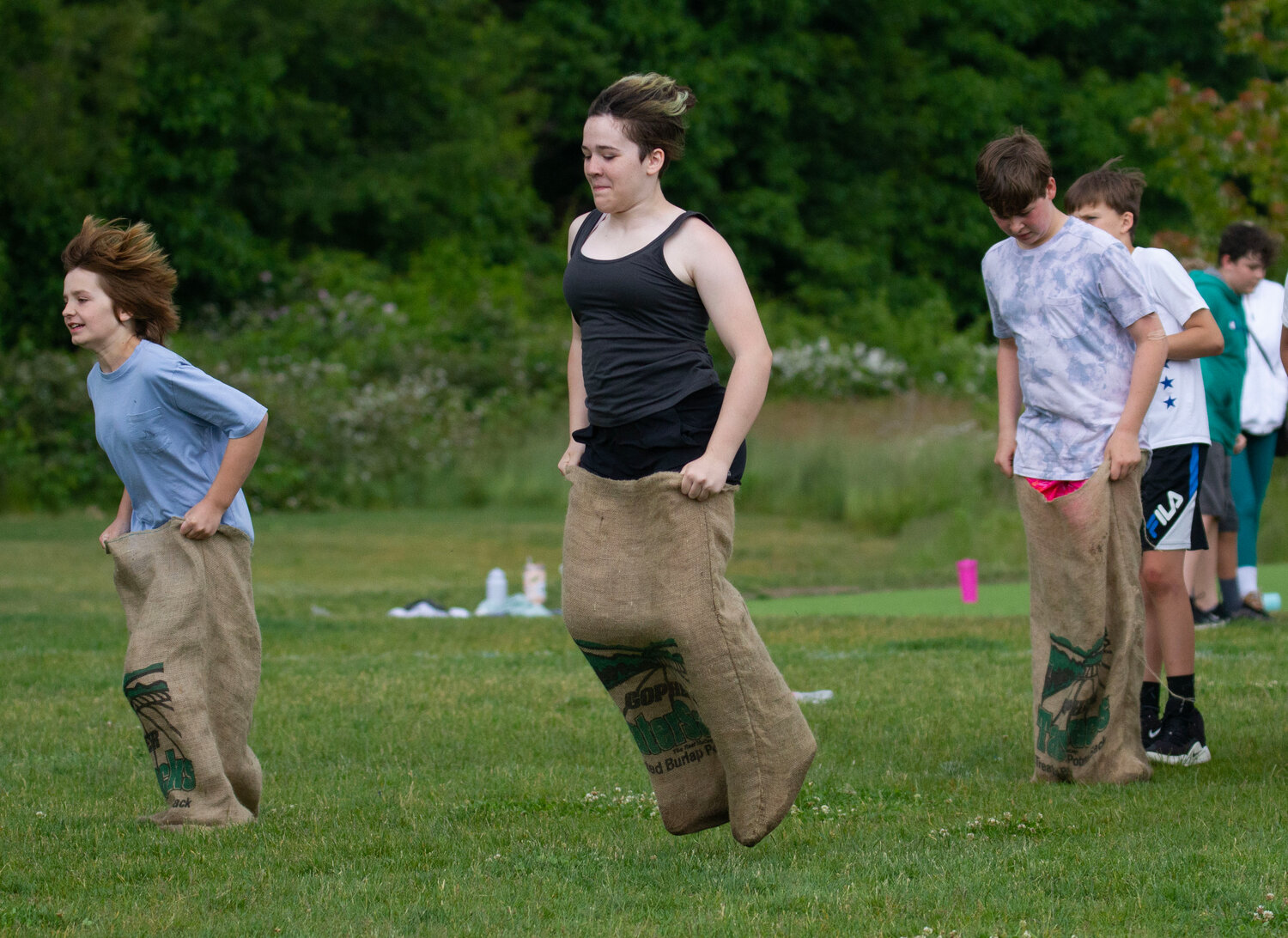 Olivia Clare (middle) competes in the sack race during Field Day at Barrington Middle School.