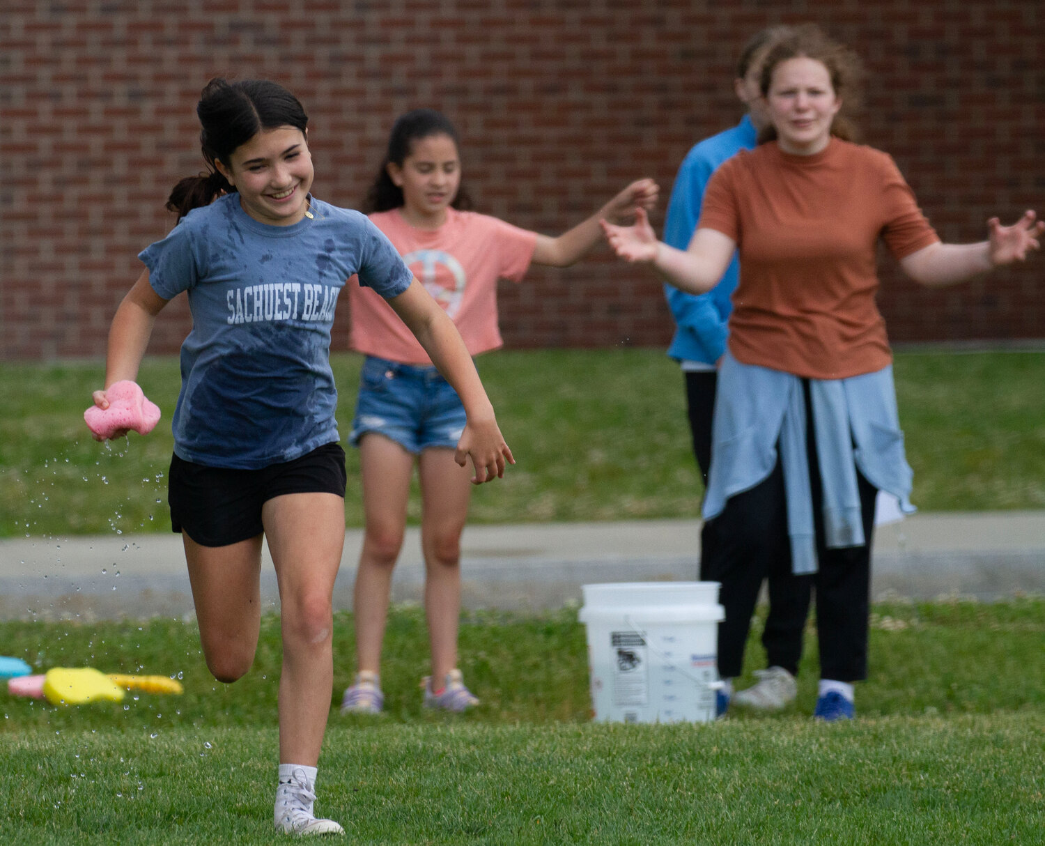 Harper Boyajian sprints with a sponge during the sponge race event at the Lime Cluster Field Day at Barrington Middle School on Friday.