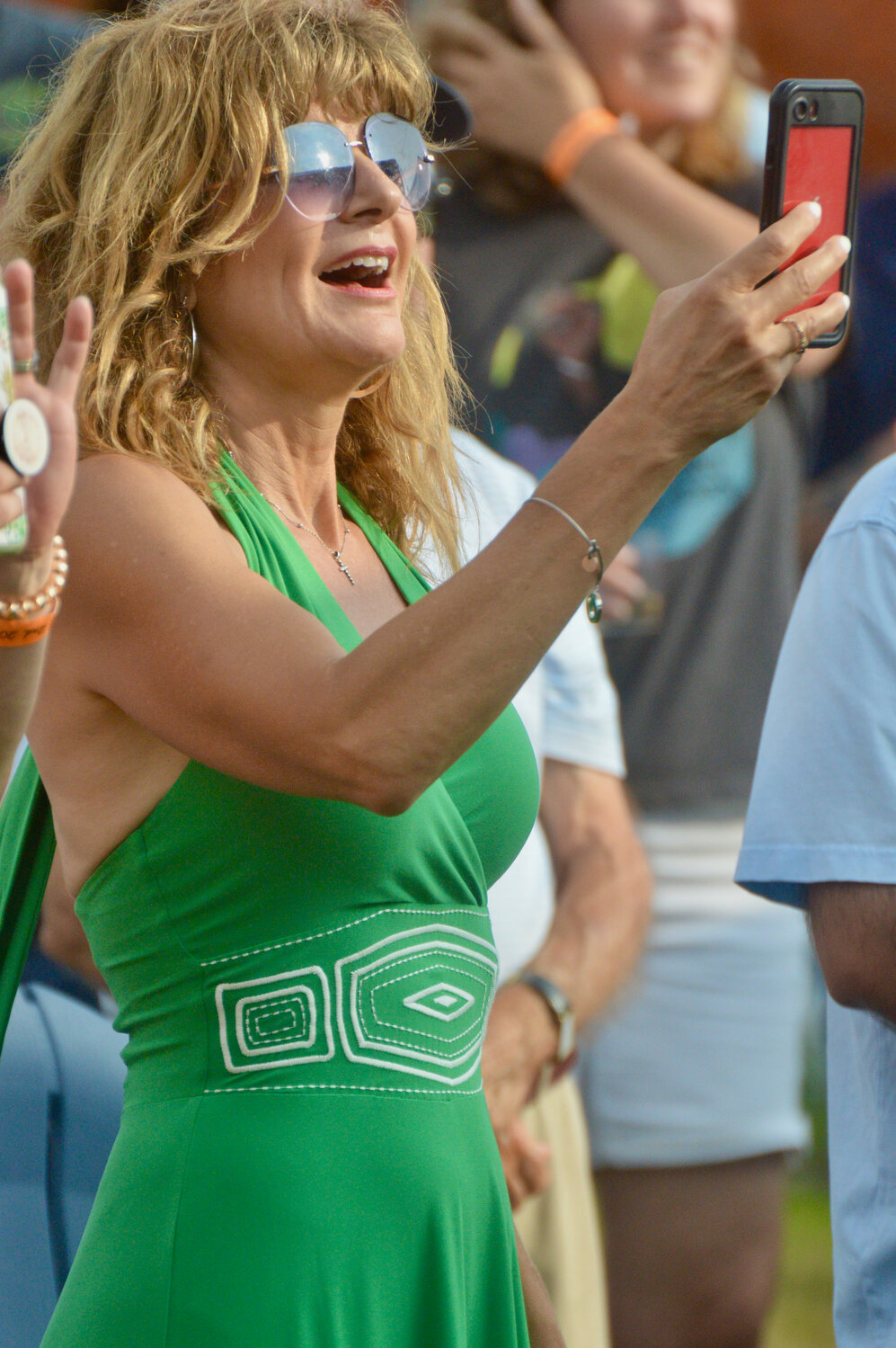Suzanne Kekligian takes a video of Jimmy Buffett performing from in front of the stage.